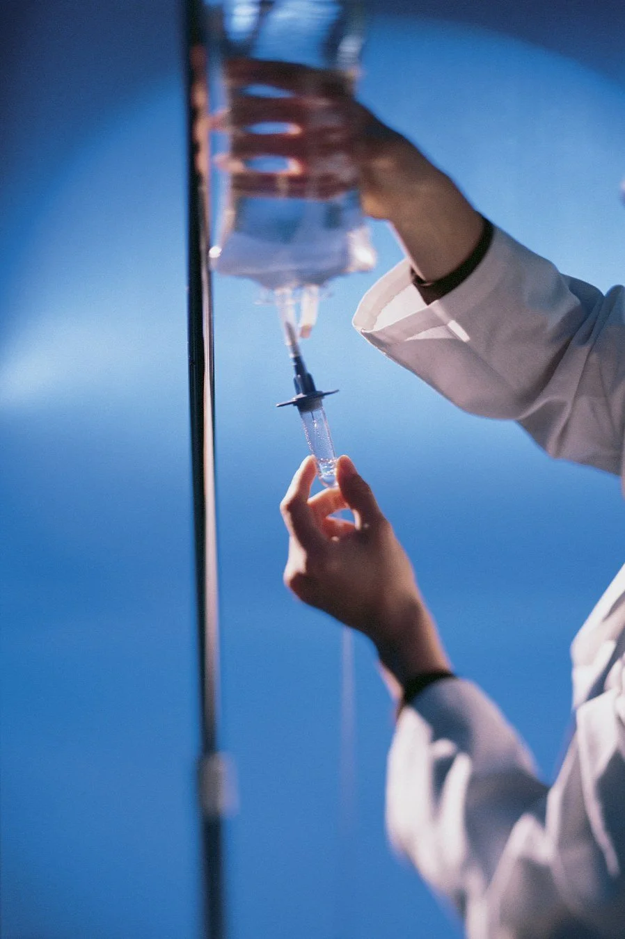 A clinician preparing an IV drip