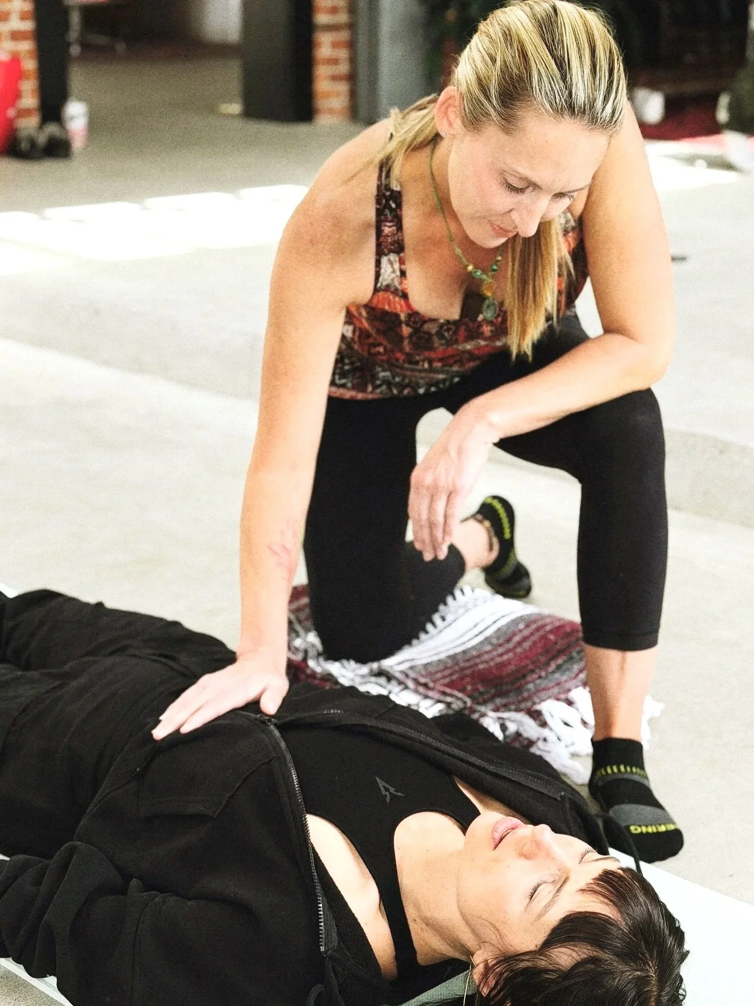 Nikki LaFord guiding a client through a somatic breathwork session, lying down