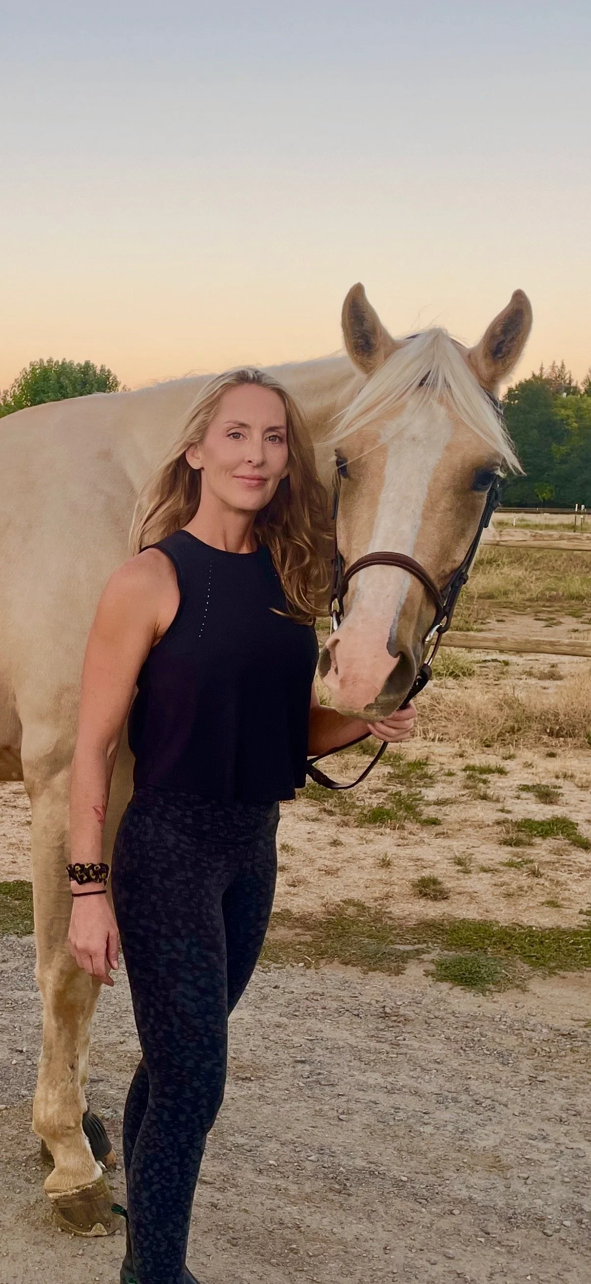 Nikki LaFord standing with a palomino horse in an arena