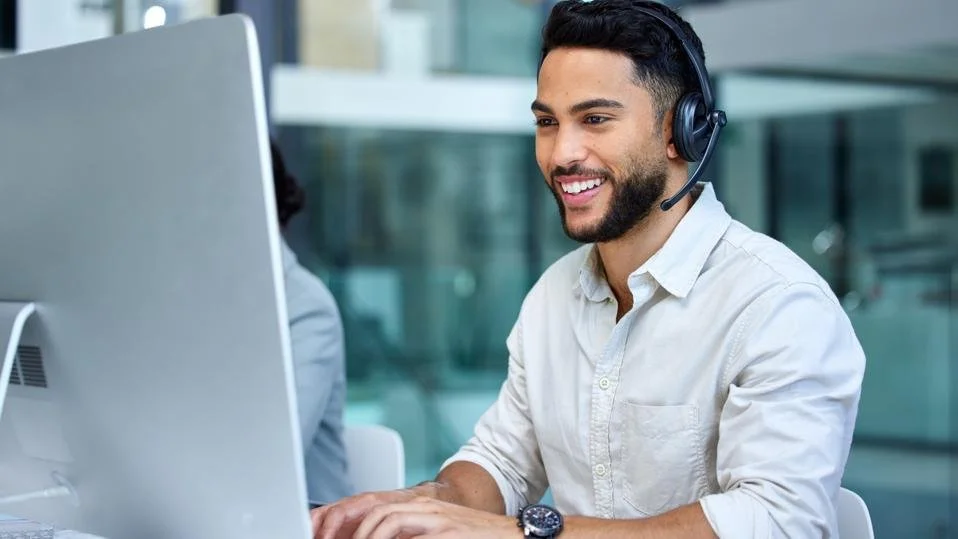 Man met headset werkt aan computer in kantoor