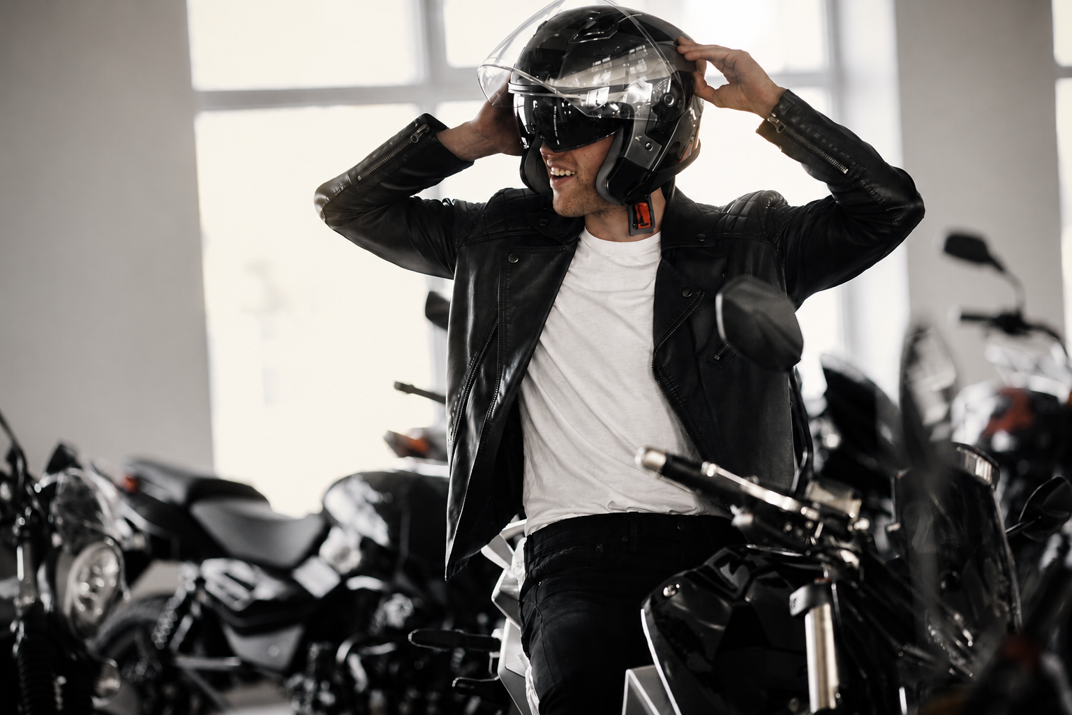 Man die zijn helm op een motorcycle zet in een showroom met meerdere motorfietsen.