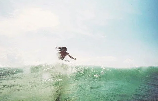 Person surfing on a wave in the ocean during daylight hours.