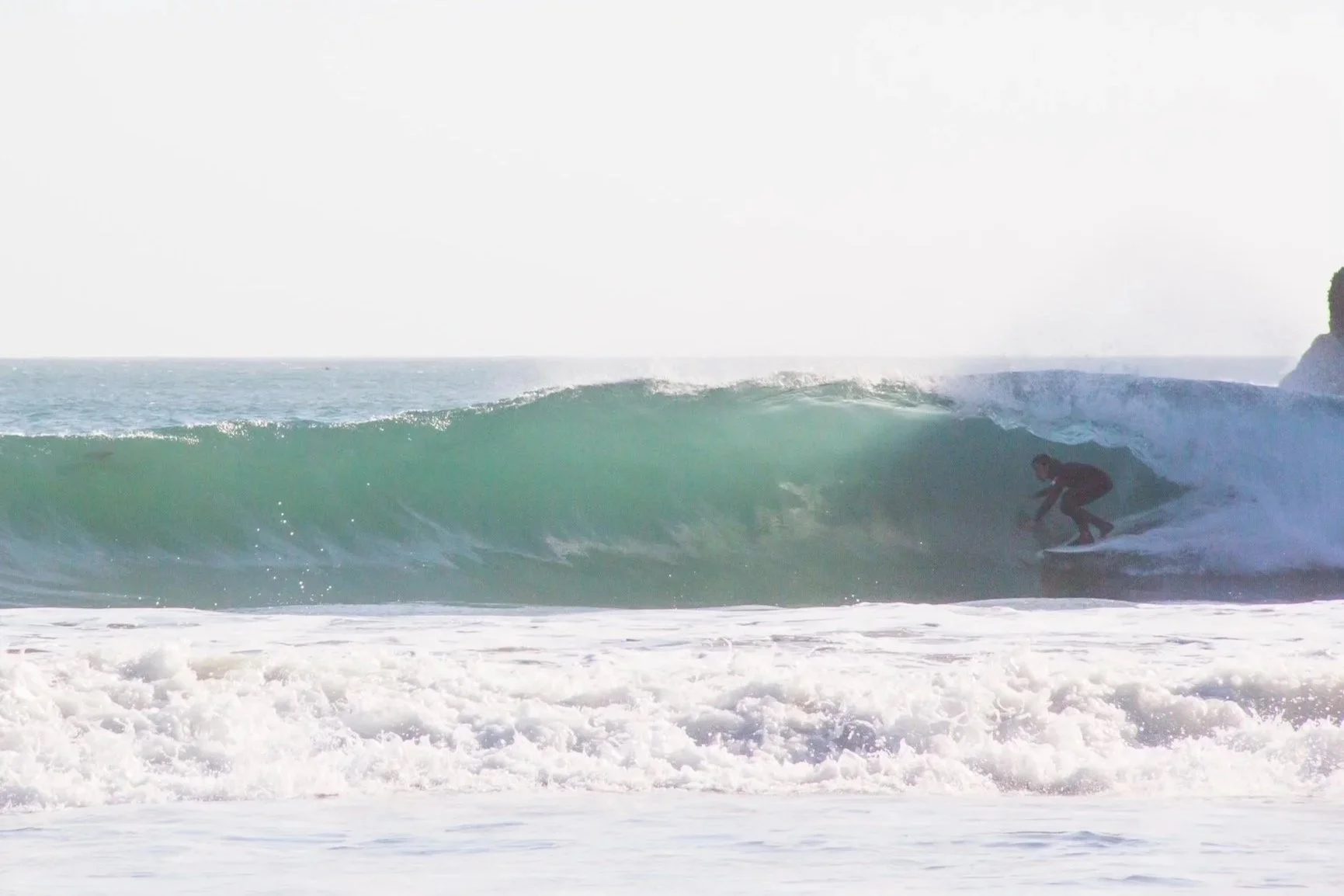 Person surfing a wave at the beach.