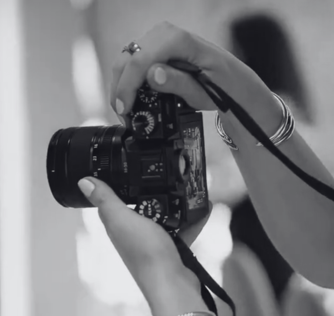 A person holding a digital camera ready to take a photograph.