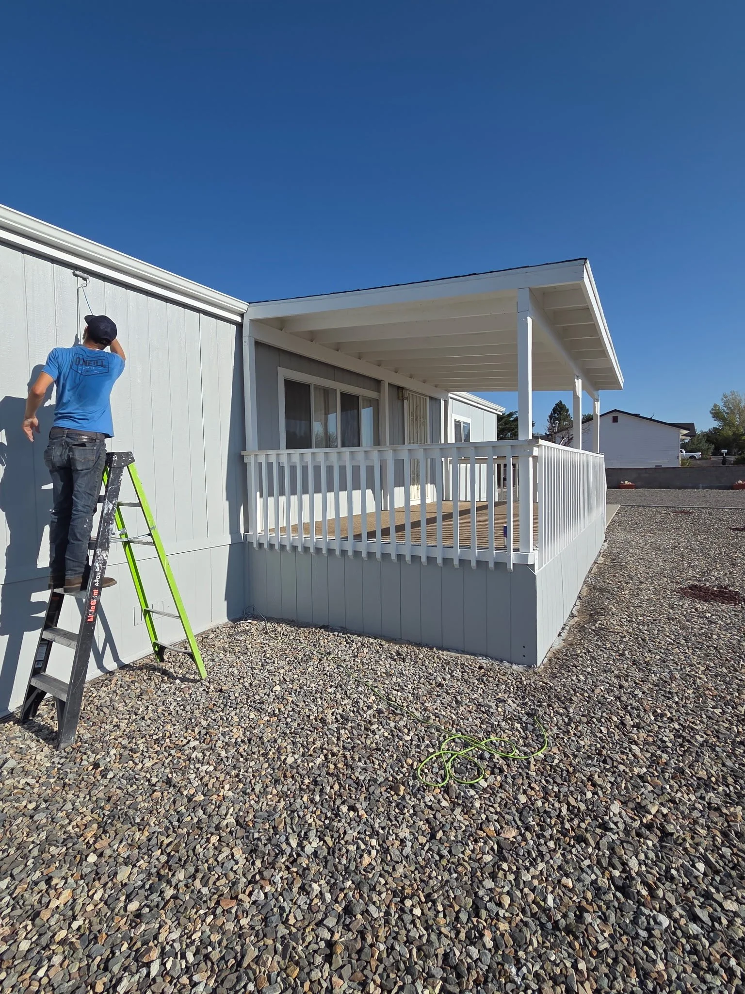 In progress: Riley painting the exterior near the front porch