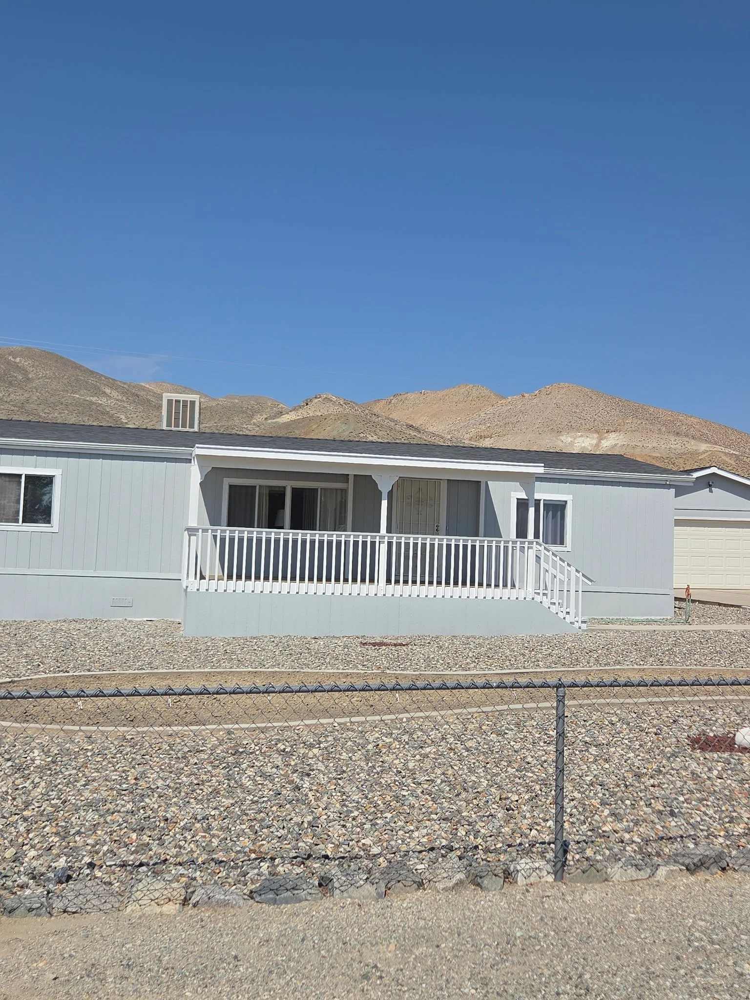 After: completed exterior painting with soft gray siding and crisp white trim