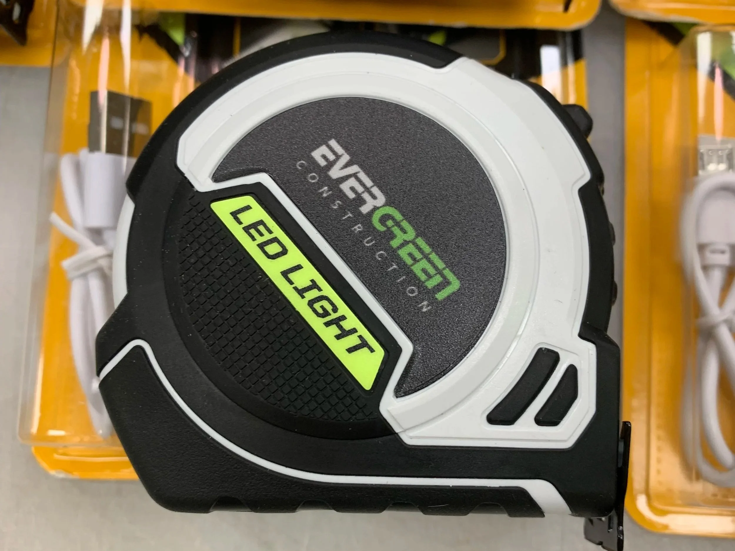 Close-up of a green and black measuring tape labeled 'LEAD LIGHT', displayed on a store shelf.