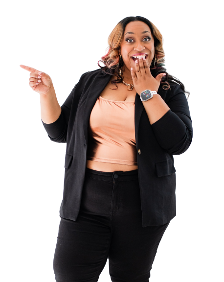 A woman with medium skin tone, curly hair with highlights, wearing a peach top, black blazer, and black pants, smiling and pointing to her left with her hand covering her mouth.