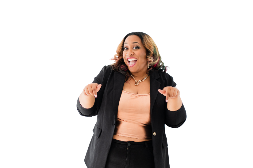 Happy woman with shoulder-length hair, wearing a black blazer and pink top, smiling and pointing with both hands.