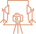 A camera on a tripod set up in front of a photo backdrop and studio lights.