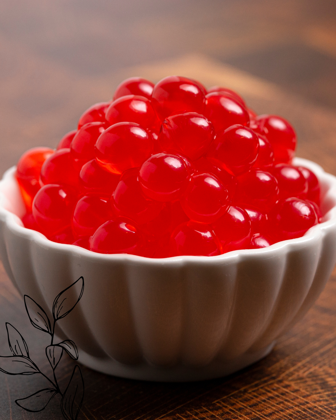 A white ceramic bowl filled with bright red, shiny salmon roe (fish eggs) on a wooden surface.