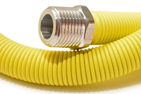Close-up of a yellow flexible conduit hose with a metallic threaded fitting.