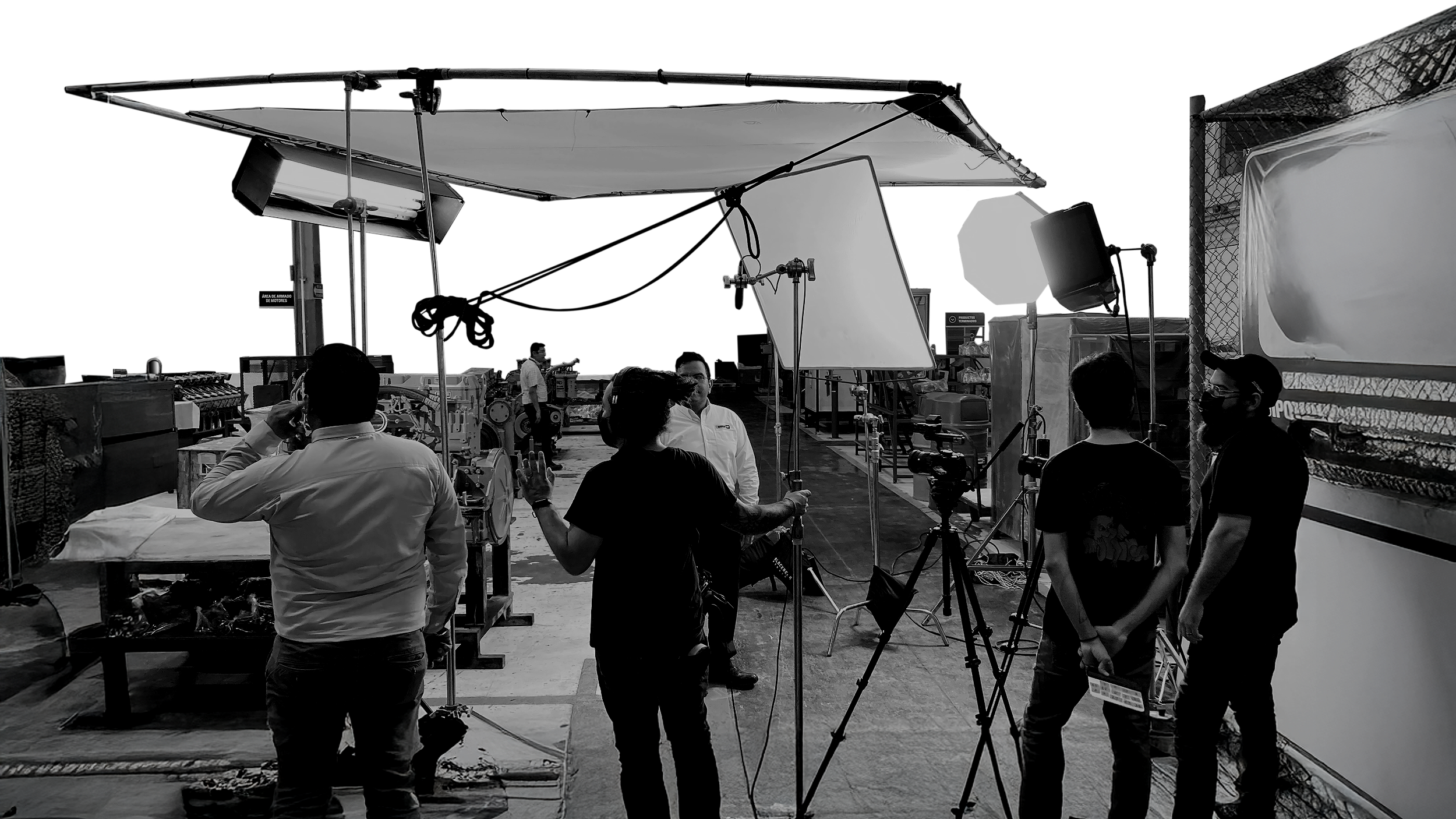 Filming setup outdoors with large reflectors, lights, and crew members preparing for a shoot.