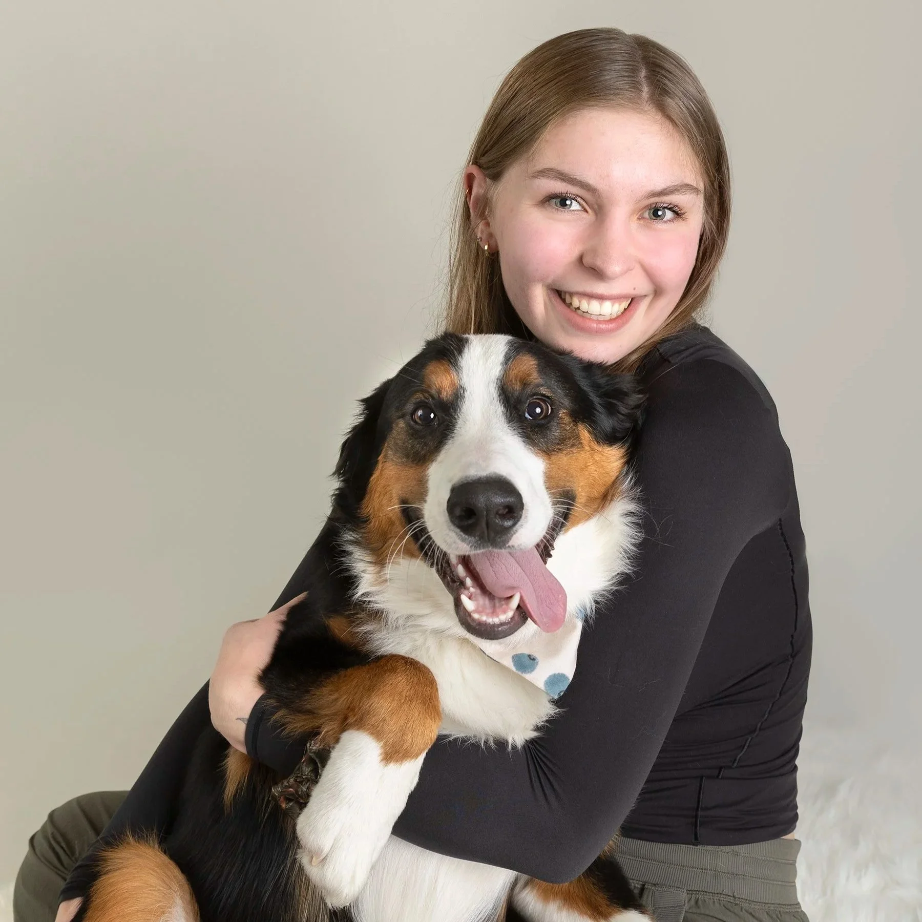 Kitchener studio portrait of girl hugging her dog — Warm, playful image showing a joyful dog being held close.
