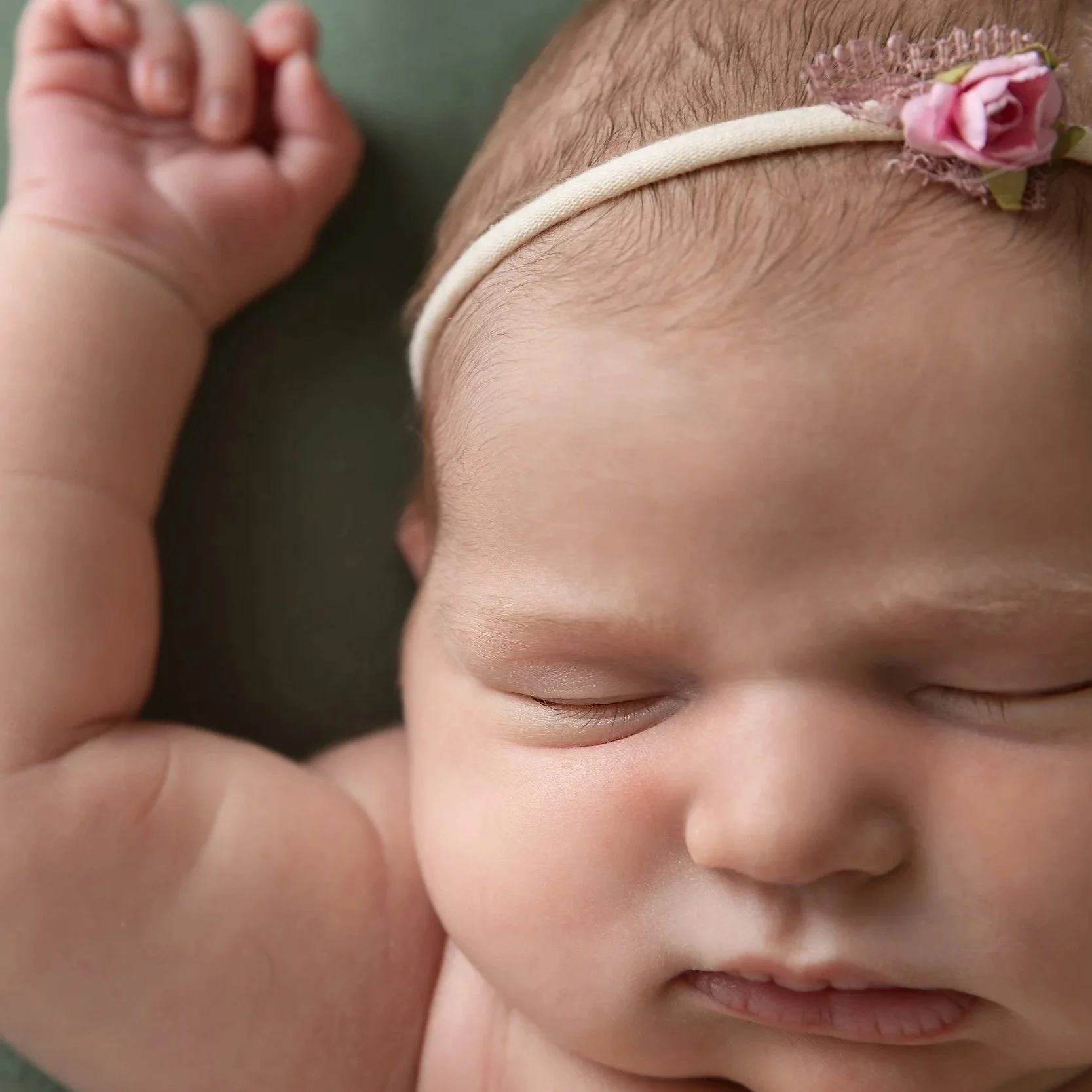 Waterloo Region newborn girl portrait in pink and sage — Soft, detailed close‑up highlighting delicate newborn features.