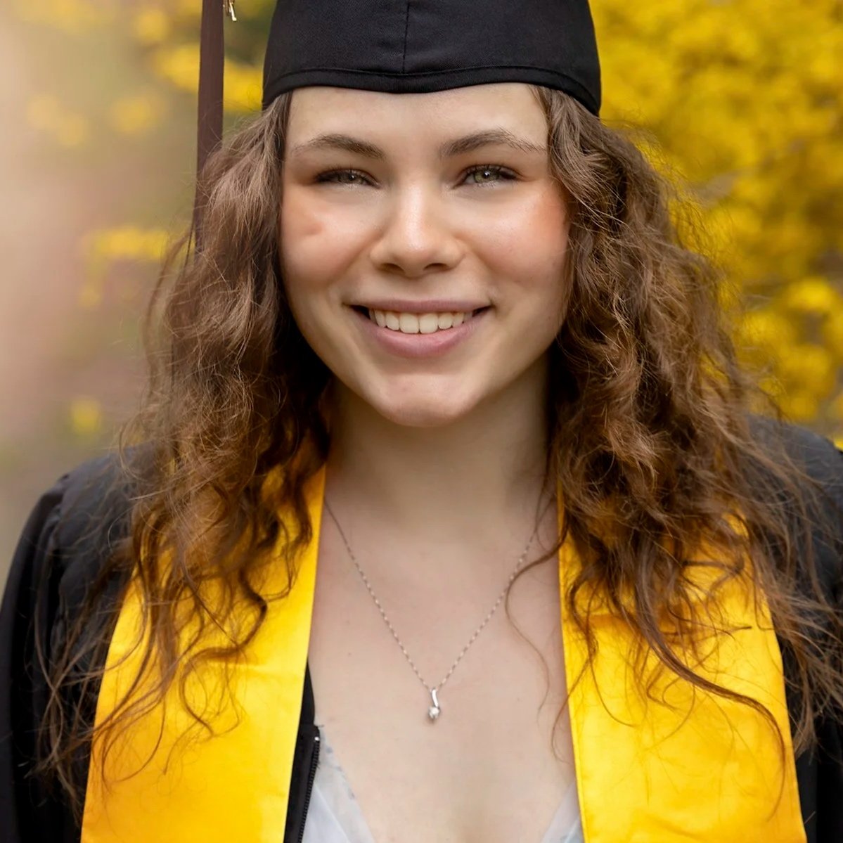 University graduate photographed in a modern senior session in Waterloo, celebrating her achievement with soft, natural light and joyful, confident styling