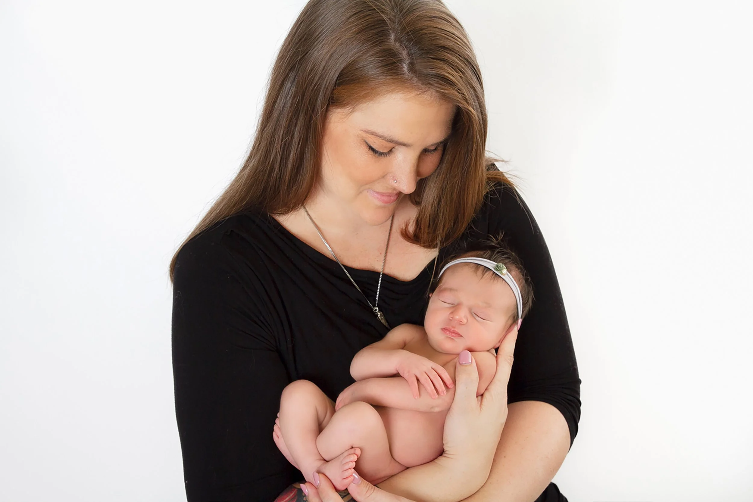 Waterloo Region newborn girl portrait with parent — Tender moment featuring a sleeping newborn held close.
