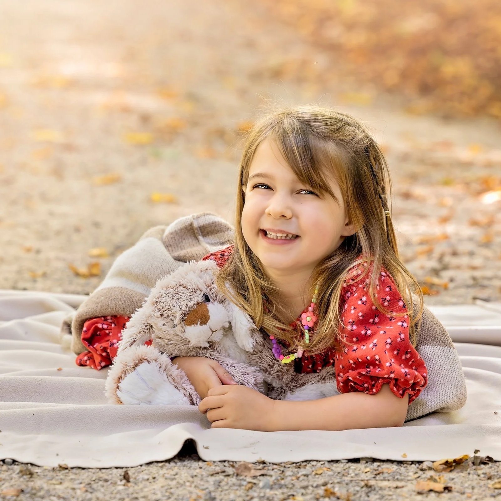 Little girl during a fall session in Steckle Woods, Kitchener holding her stuffed bunny, photographed by Janelle Joy Studios
