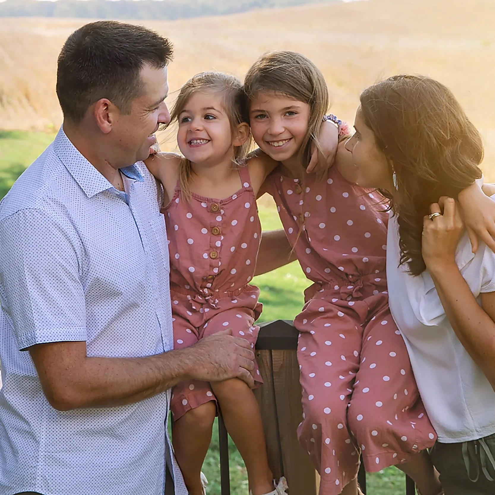 Family farm photography session in St. Agatha Ontario — Warm, relaxed portrait of a family surrounded by soft farm light and open fields.