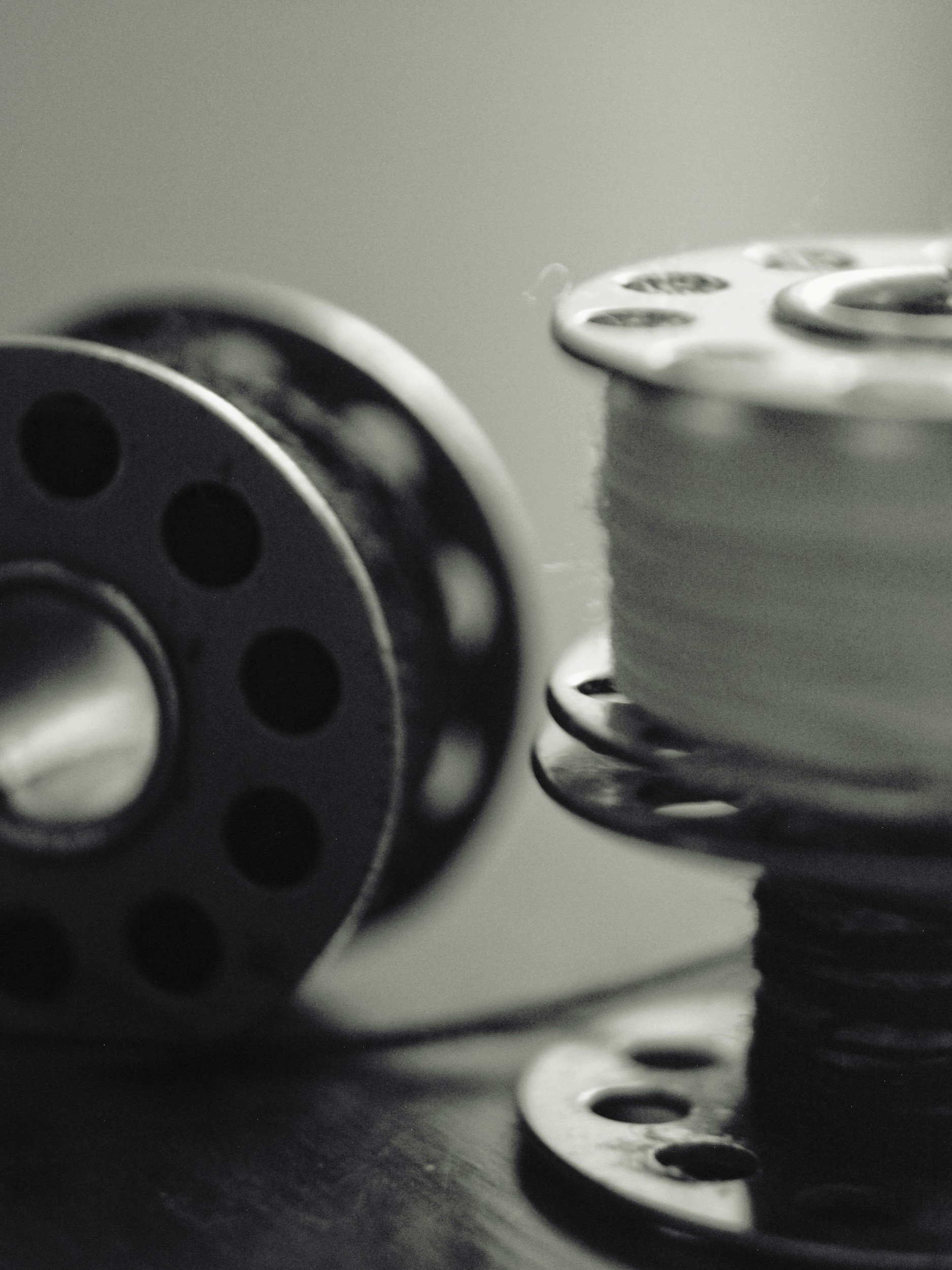 Close-up of metallic sewing bobbin in a monochrome setting.