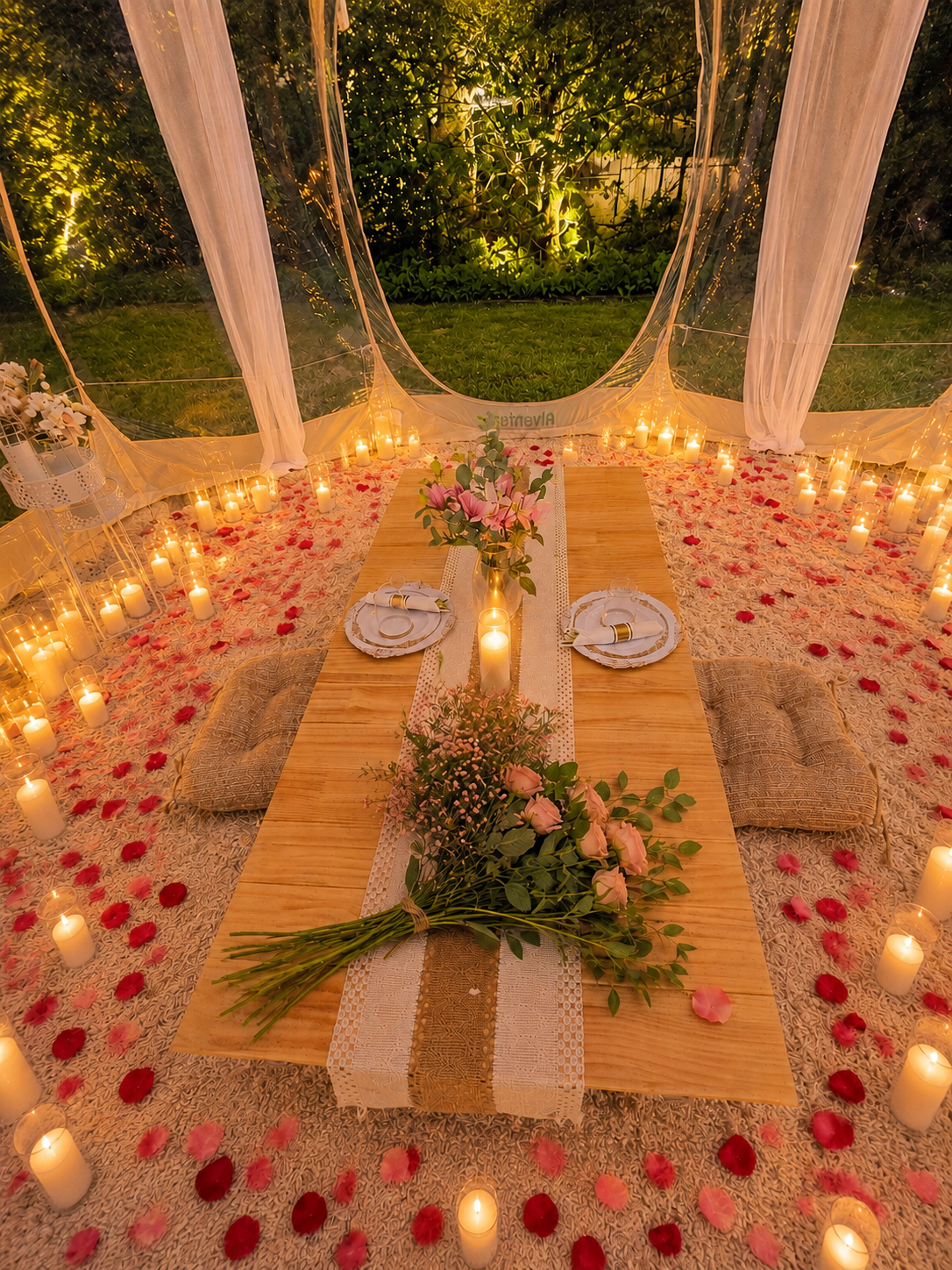 Romantic picnic in a clear pop-up tent in Minnesota featuring candles, rose petals, elegant floral décor, comfortable seating, and a beautifully styled outdoor setting for proposals, anniversaries, and date nights.