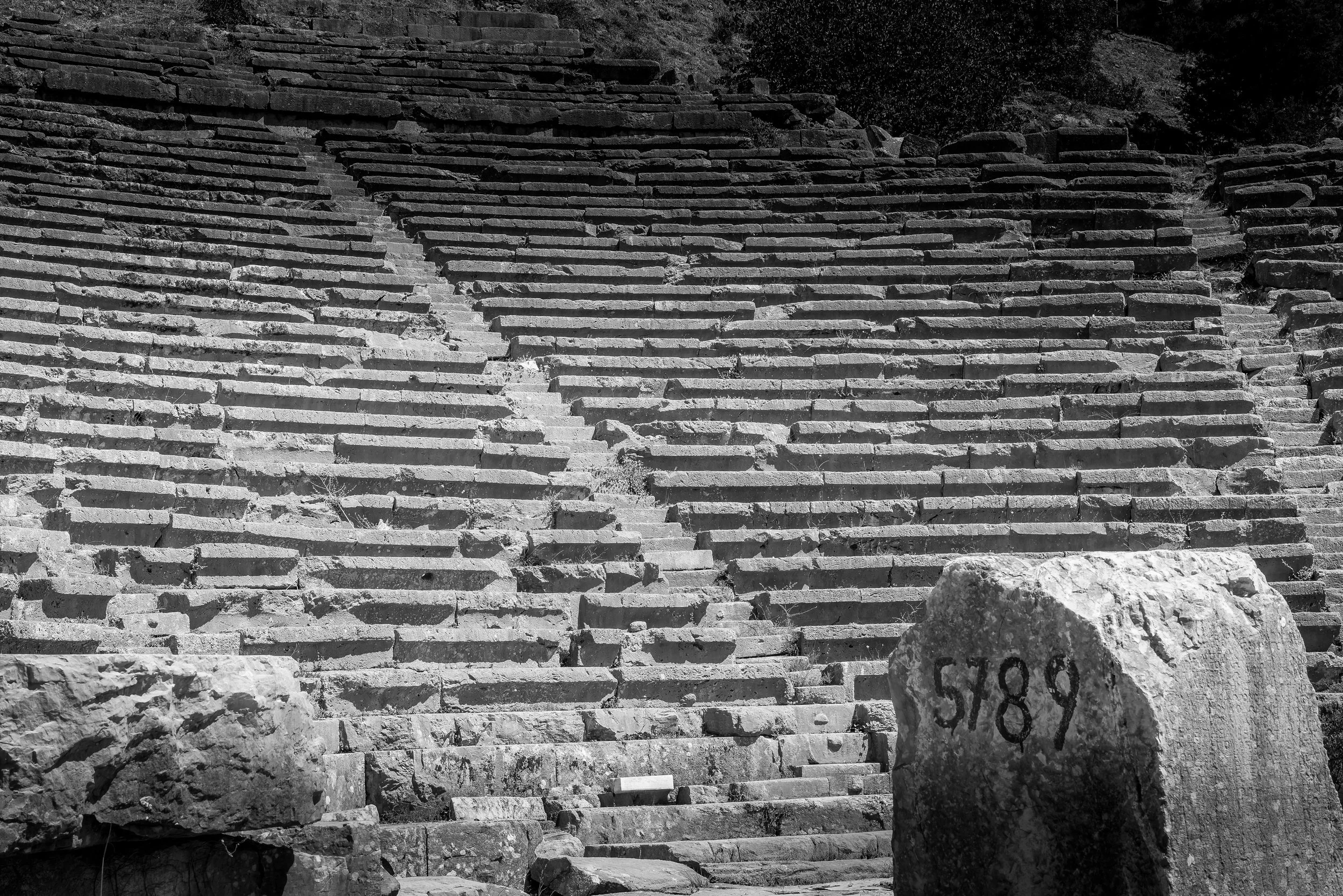 Ancient stone steps leading up a hillside with rocks and vegetation around.