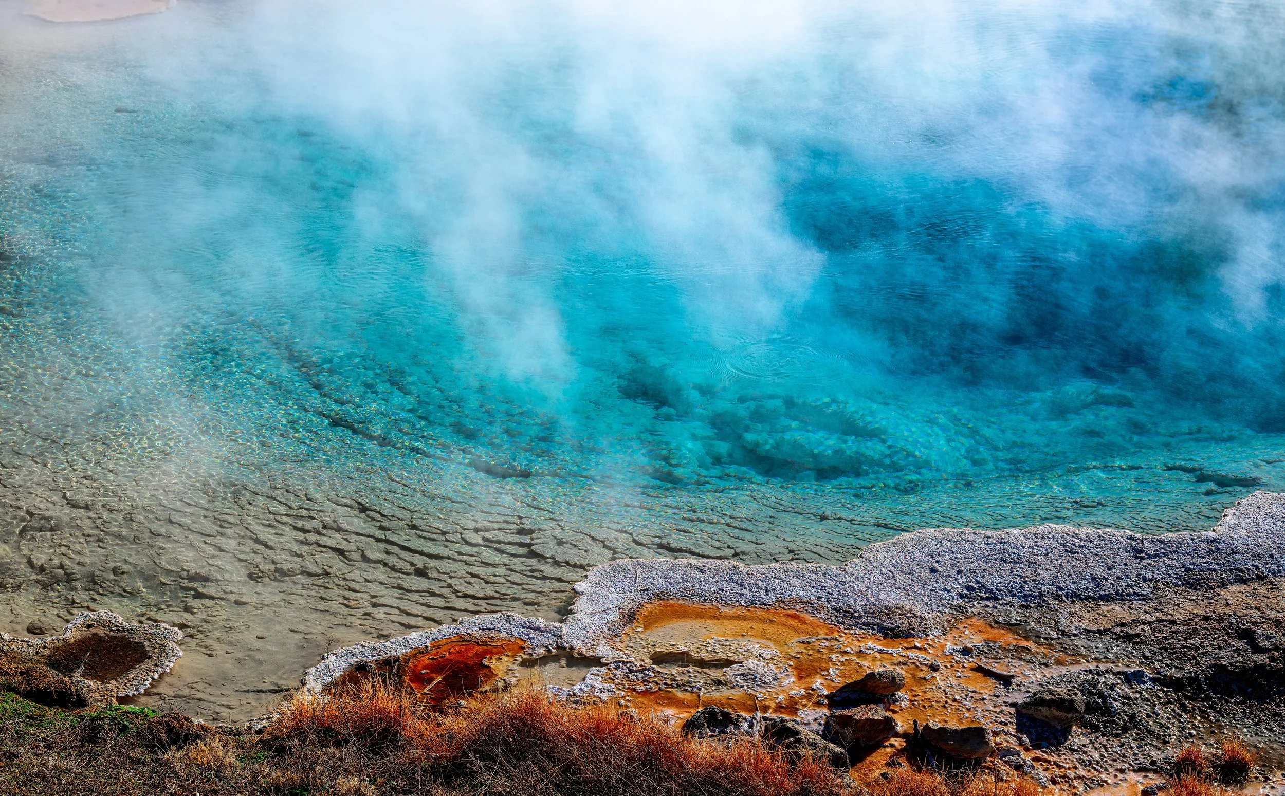 A geothermal hot spring with steam rising from the blue water. © 2026 Outgear Adventure Photography. Bruce Maxwell - Yellowstone NP