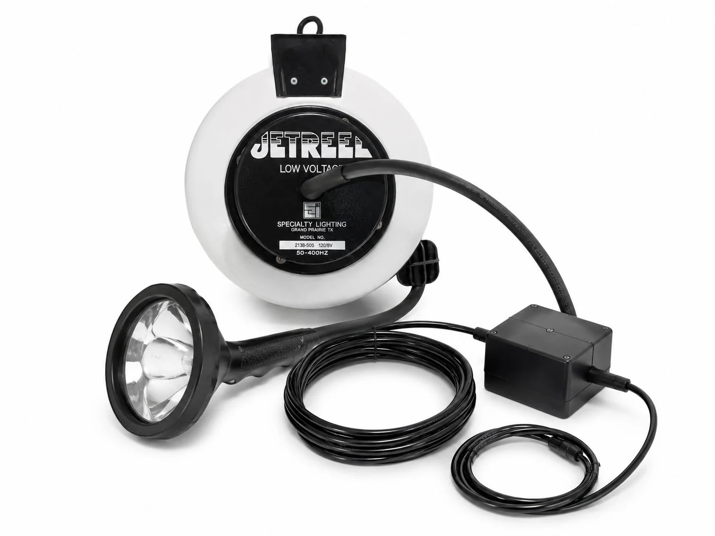A handheld spotlight with a black handle and a long power cord connected to a black power box, and a round light source, with a white and black weatherproof enclosure labeled 'Jet reel Low Voltage'.