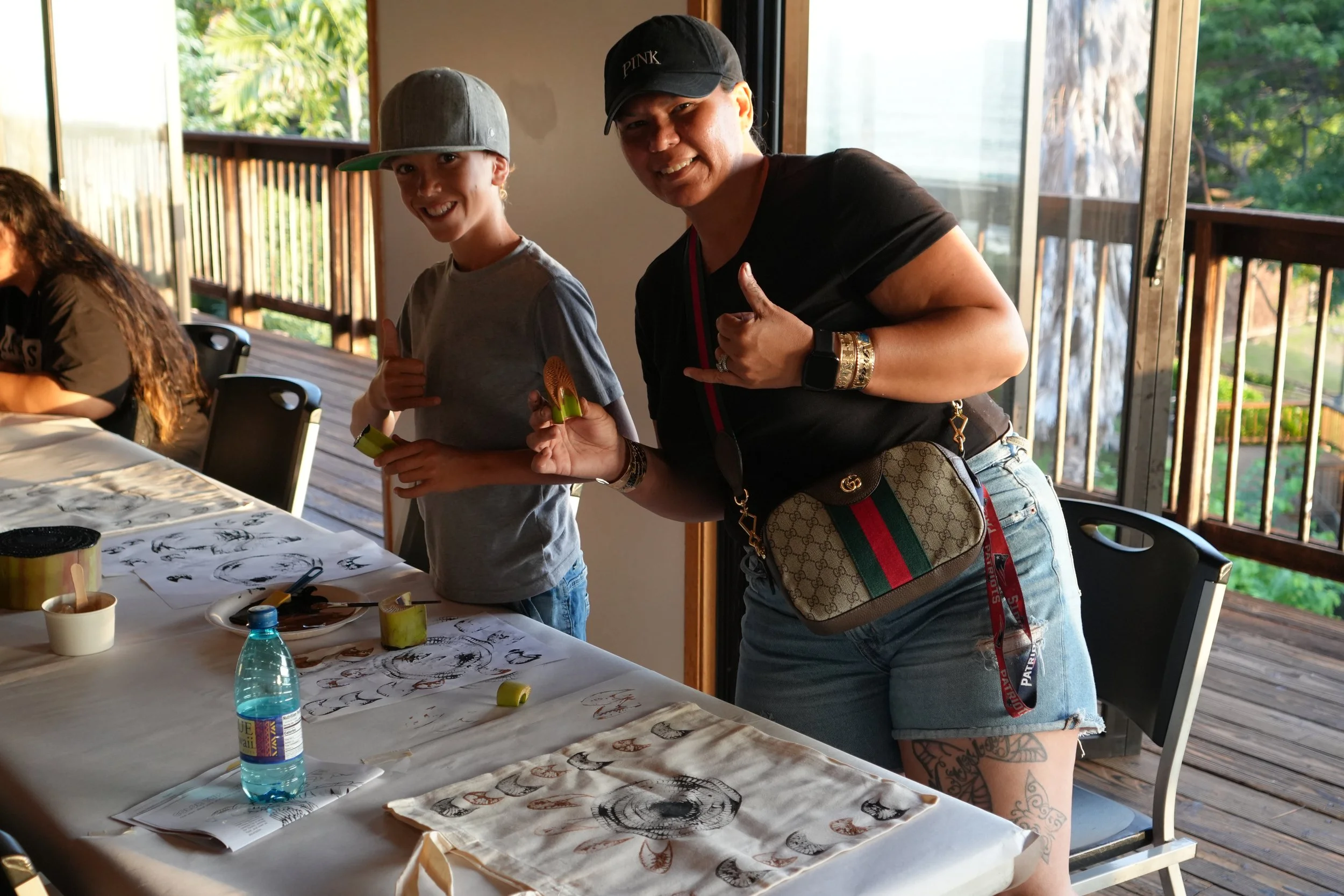 A mom and her son smile at the camera while making art at an 'Elepaio wellness workshop.JPG