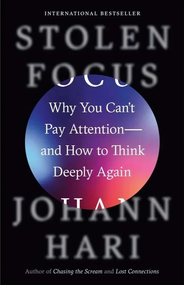 Book cover of 'Stolen Focus' by Johann Hari, with a subtitle 'Why You Can't Pay Attention—and How to Think Deeply Again'. The background is black with a colorful gradient circle in the center.