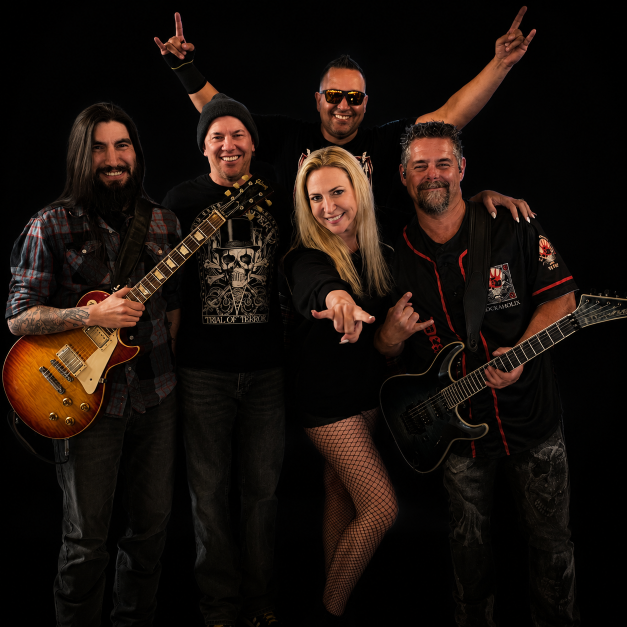 Five people in a band posing with instruments against a black background, smiling and making rock hand gestures.