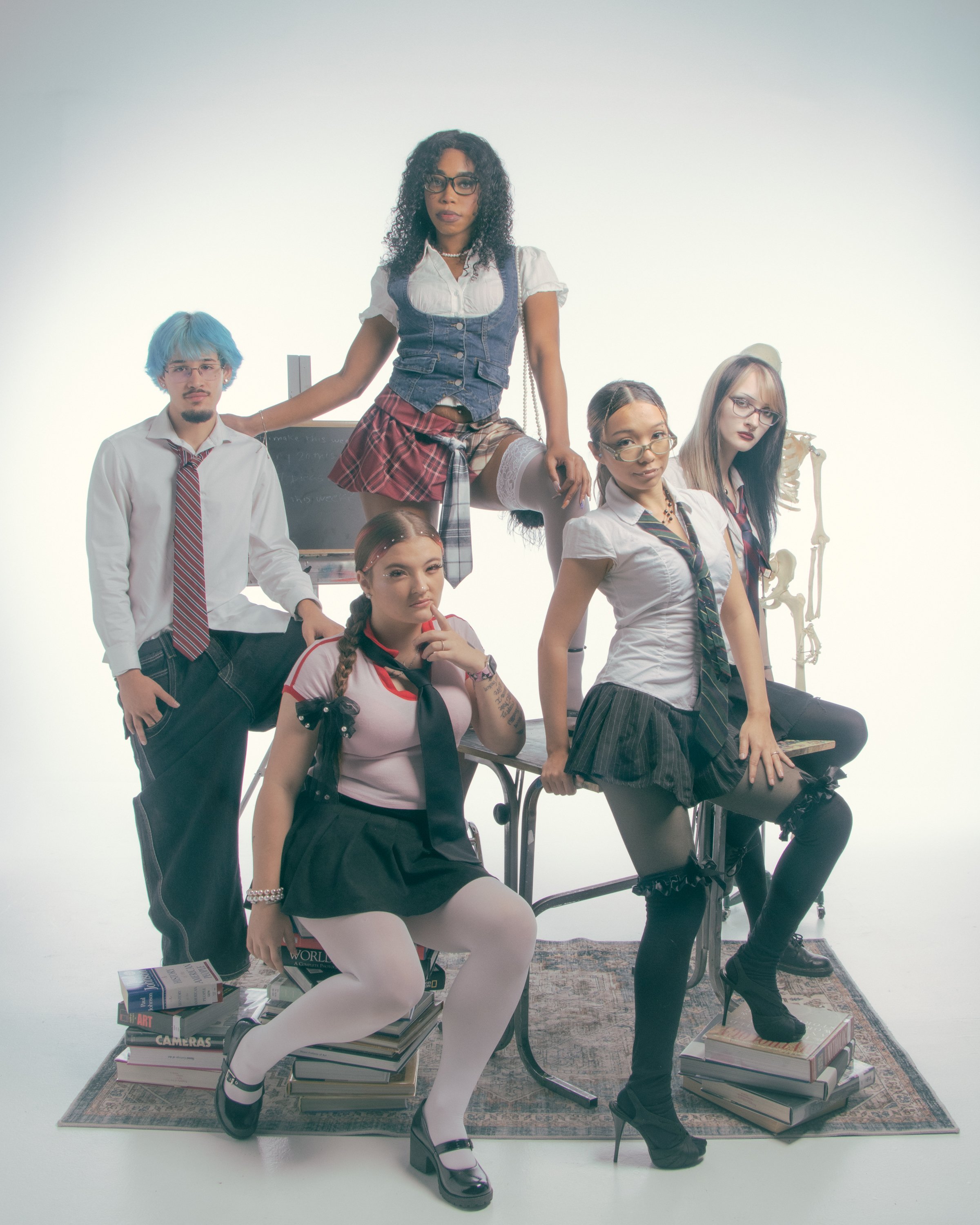 School girls with different styles posing in a studio, some standing and some sitting, surrounded by books and academic props.