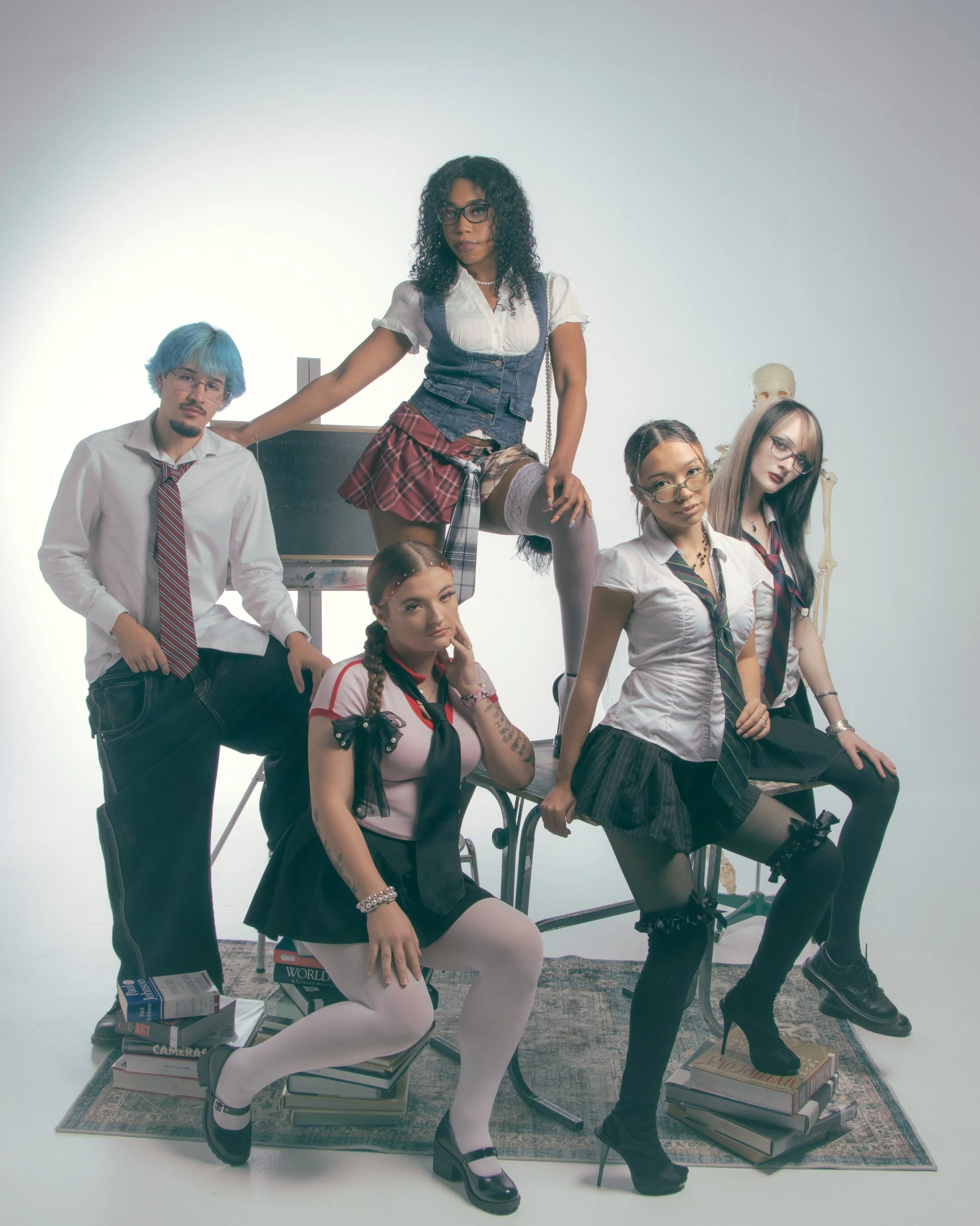 Group of diverse students in school uniforms with glasses, posing in a classroom setting filled with books, a chalkboard, and a skeleton model, with some sitting on books and others standing.