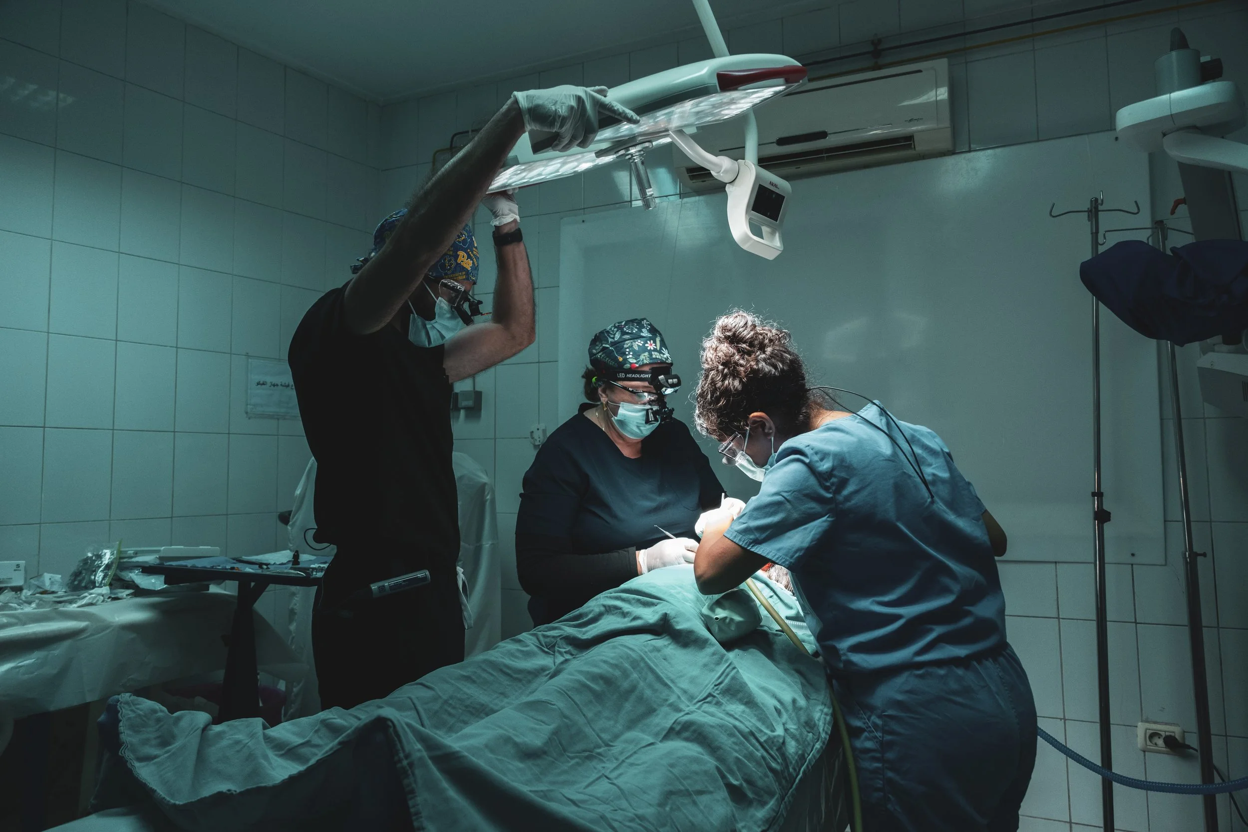 Three volunteer dentists performing a dental procedure during a CMANA medical mission in Egypt.