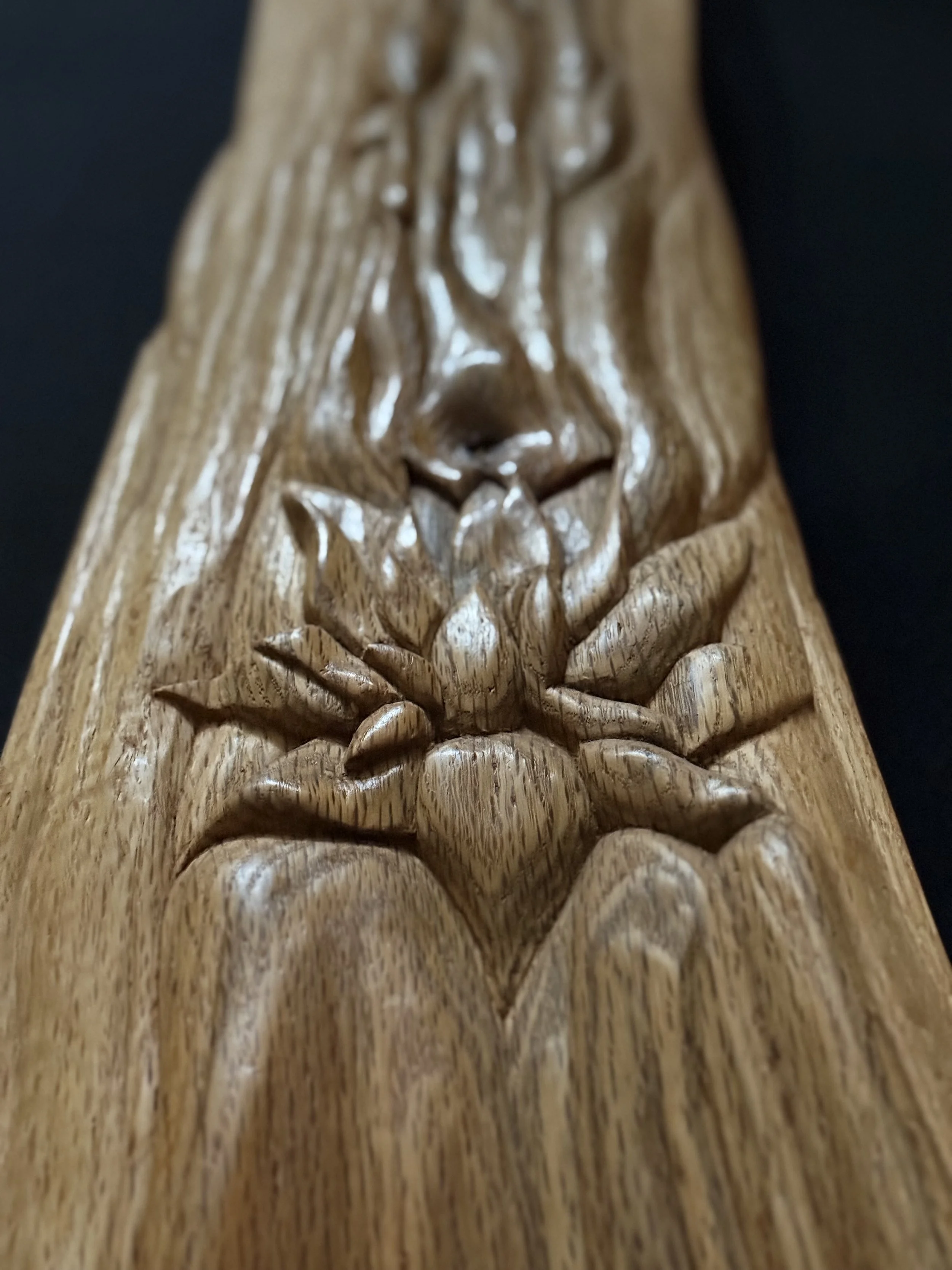 Macro close-up detail of a hand-carved contemporary wood sculpture highlighting deep chiseled facets, sharp ridges, and natural timber grain by BeckerDzine.
