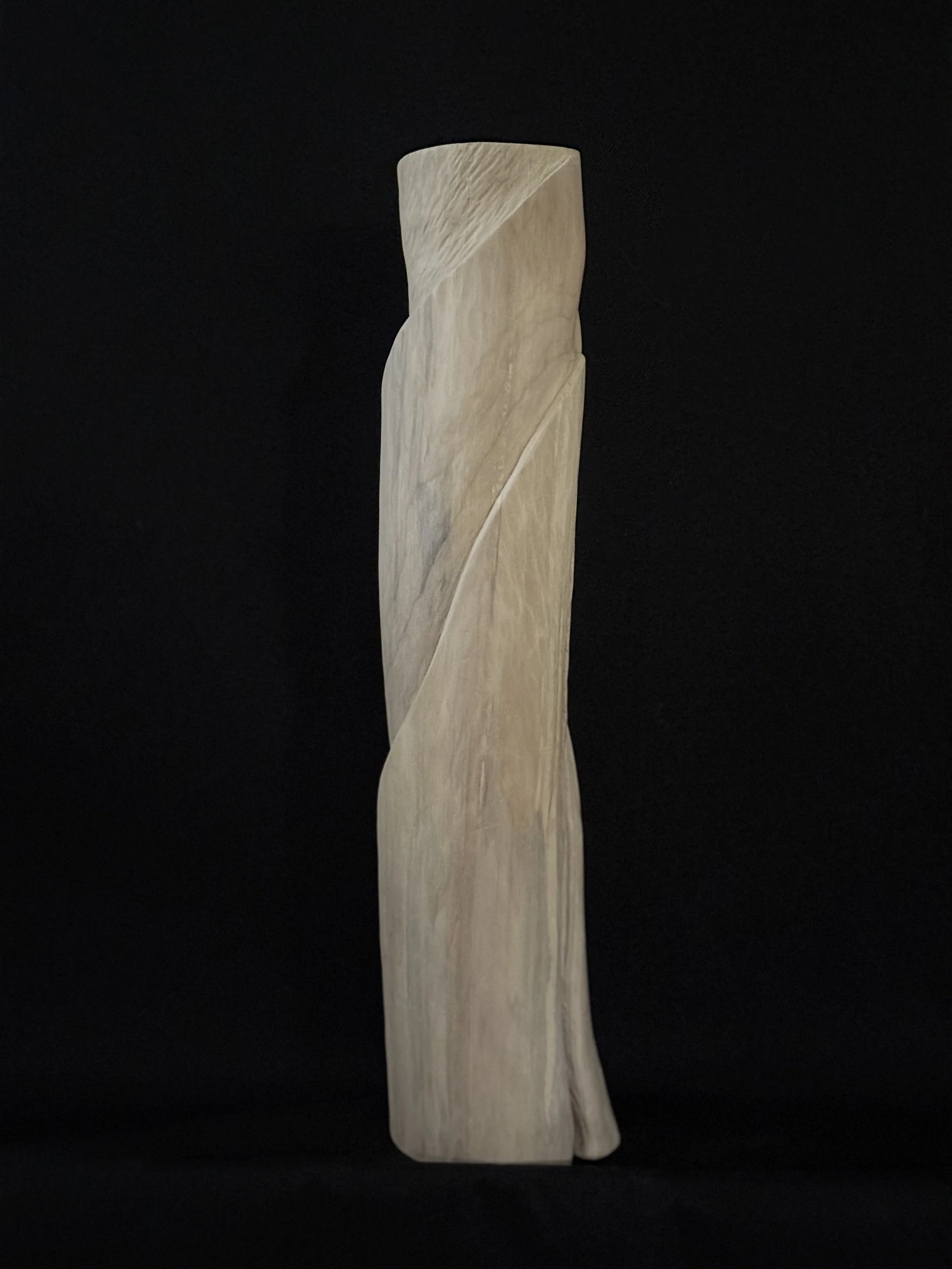 Side profile view of a medium-scale hand-carved wood sculpture showing the unique twisting spiral facet and fine grain patterns by BeckerDzine in Kansas City.