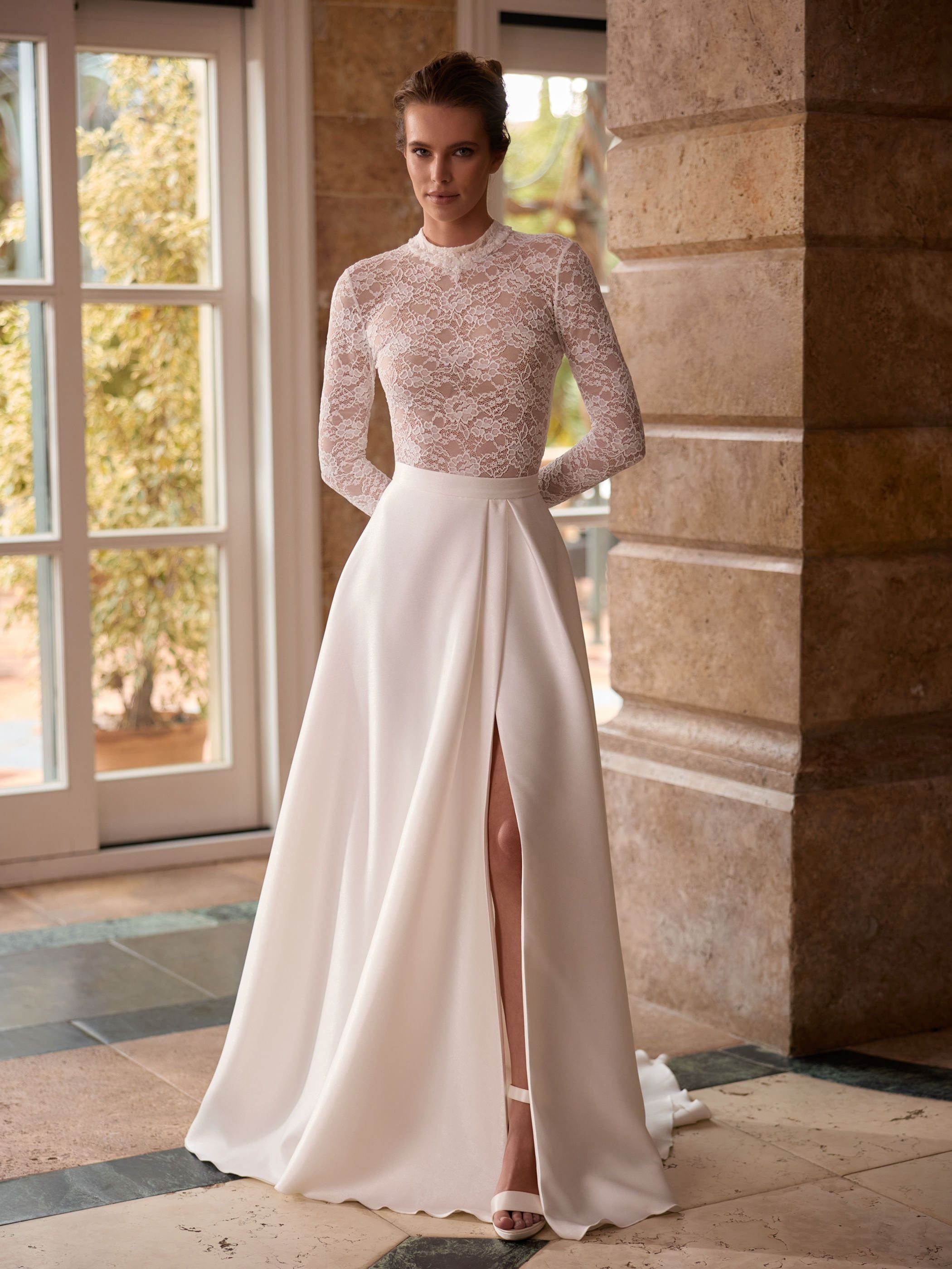 Bride in long sleeve bridal top with satin skirt box pleat and split.