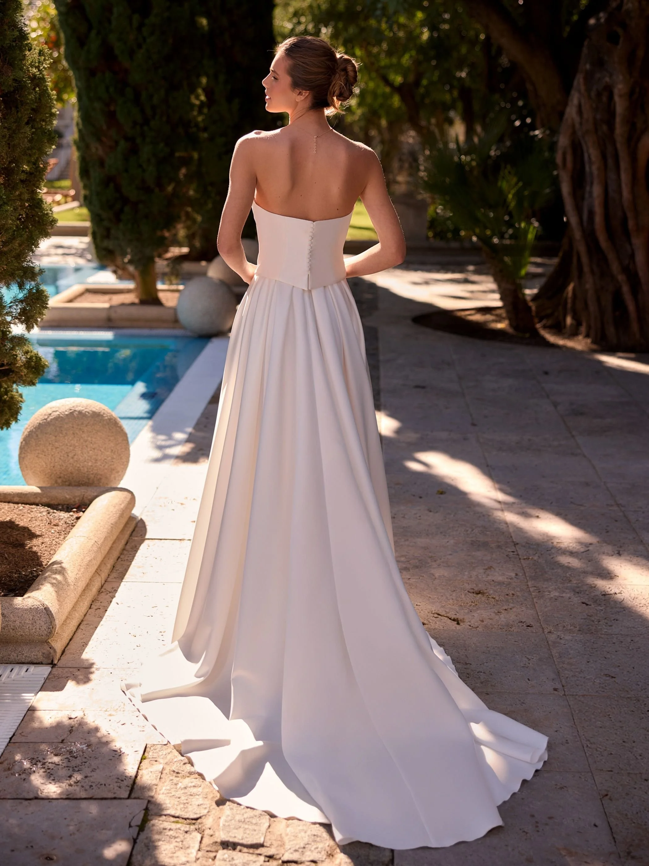 Composed showing back with corset top'.Composed bridal skirt of lux satin with generous train and box pleats