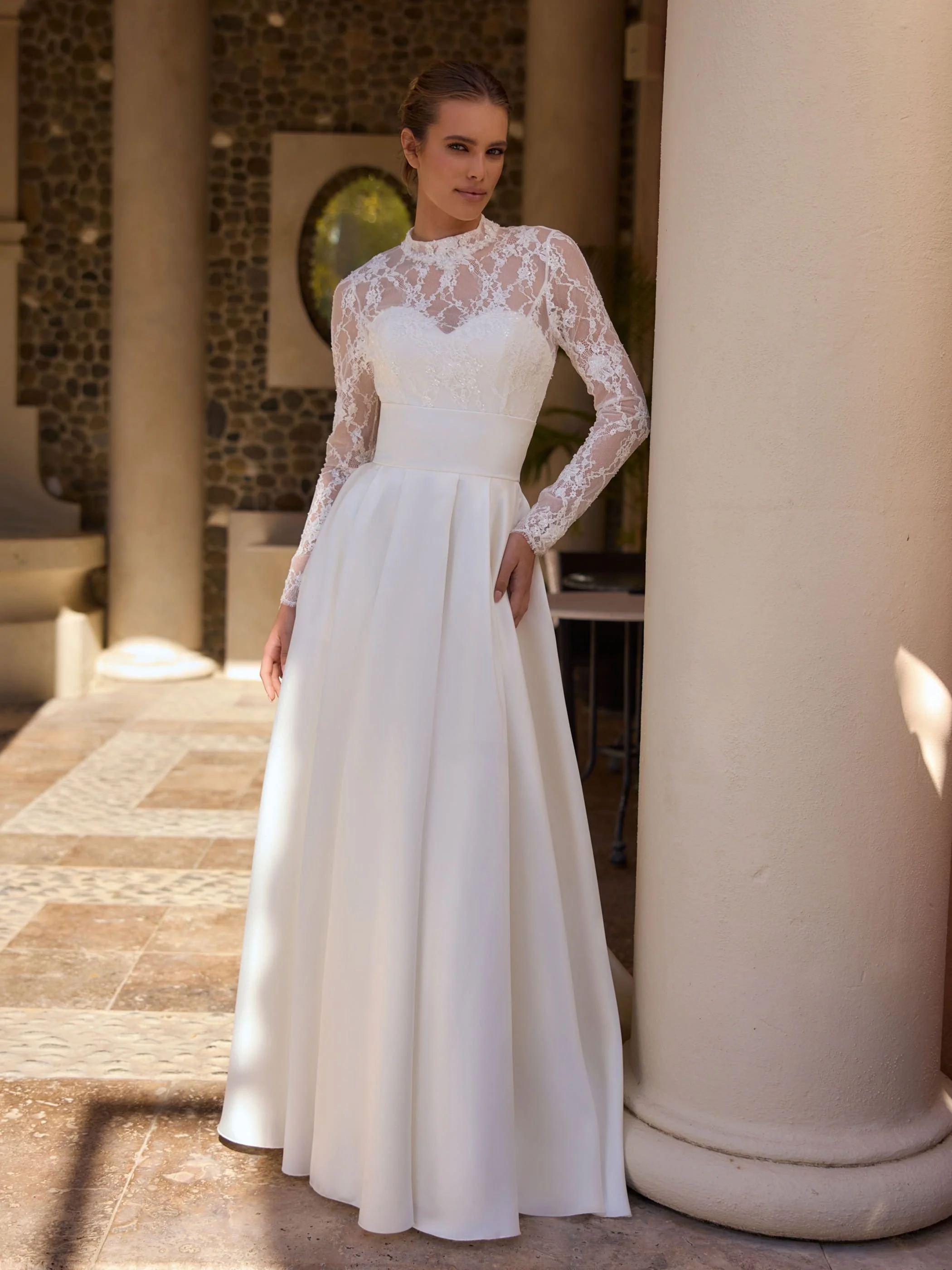 Frame skirt leaning.Image shows box pleat mikado bridal skirt (Damira by /Bianco evento)