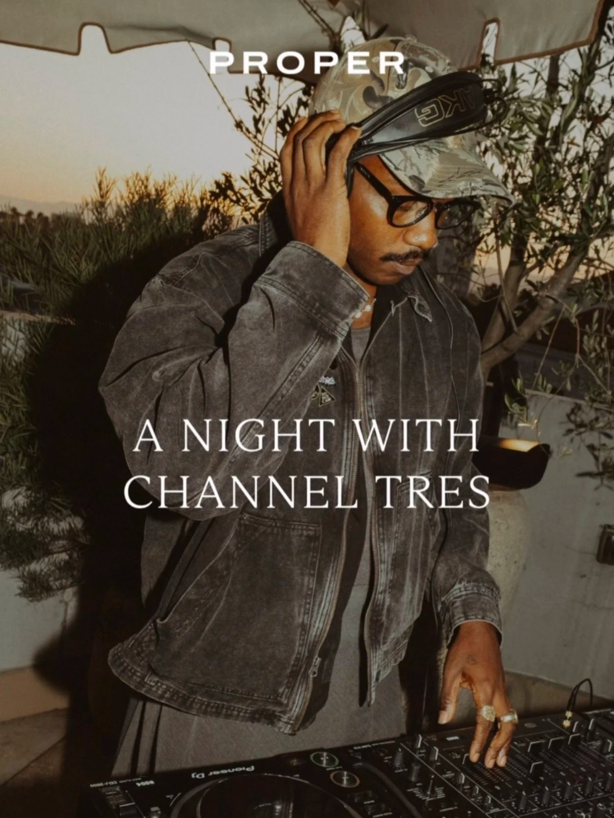 A man DJing at night outdoors with trees and a tent in the background, wearing a camouflage cap and glasses, adjusting headphones and controlling DJ equipment, with overlay text reading 'PROPER A NIGHT WITH CHANNEL TRES'.