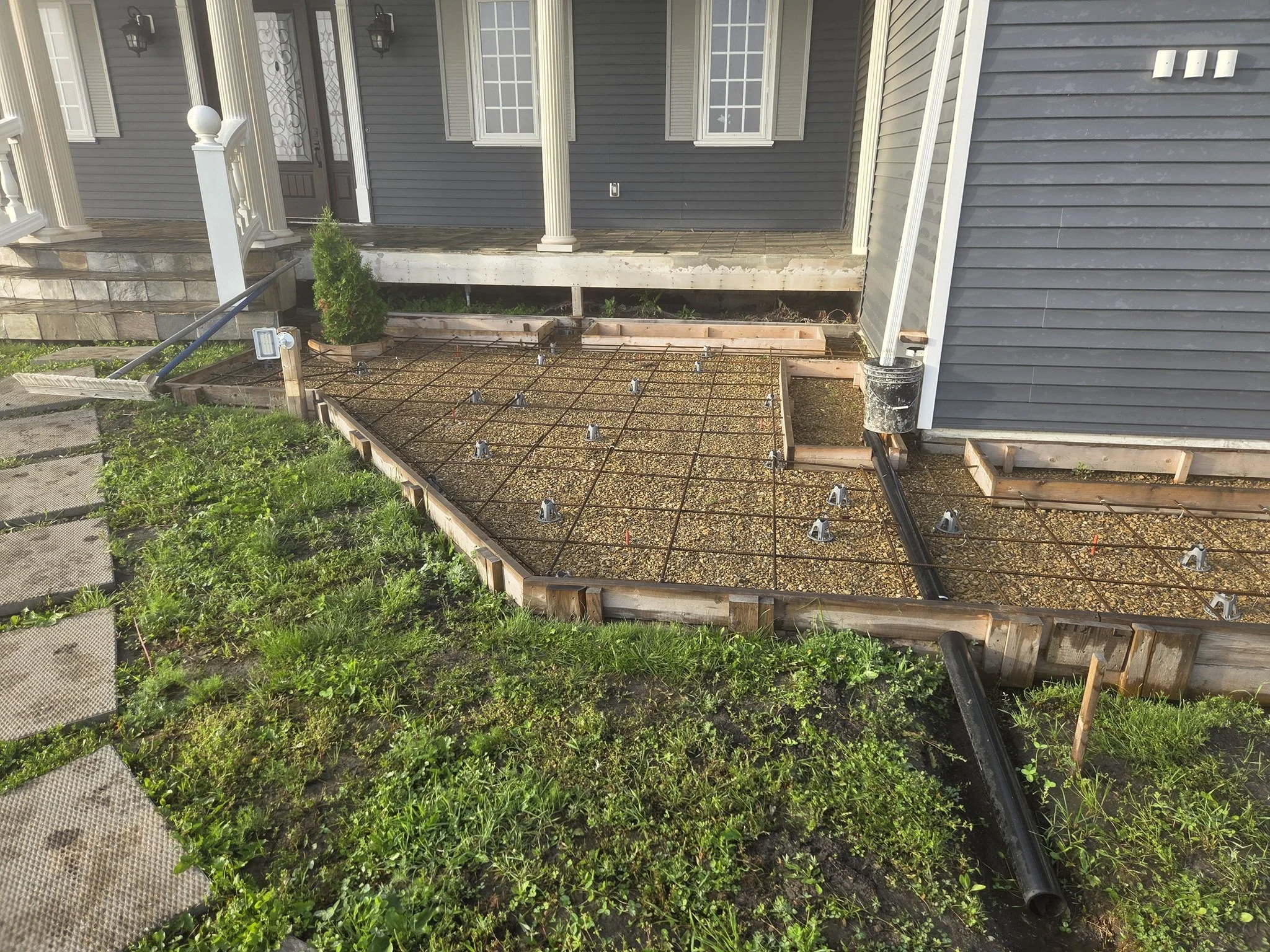 A custom engineered residential concrete sidewalk preparation featuring professional formwork, rebar grids, and drainage integration on a luxury estate acreage in Alberta.