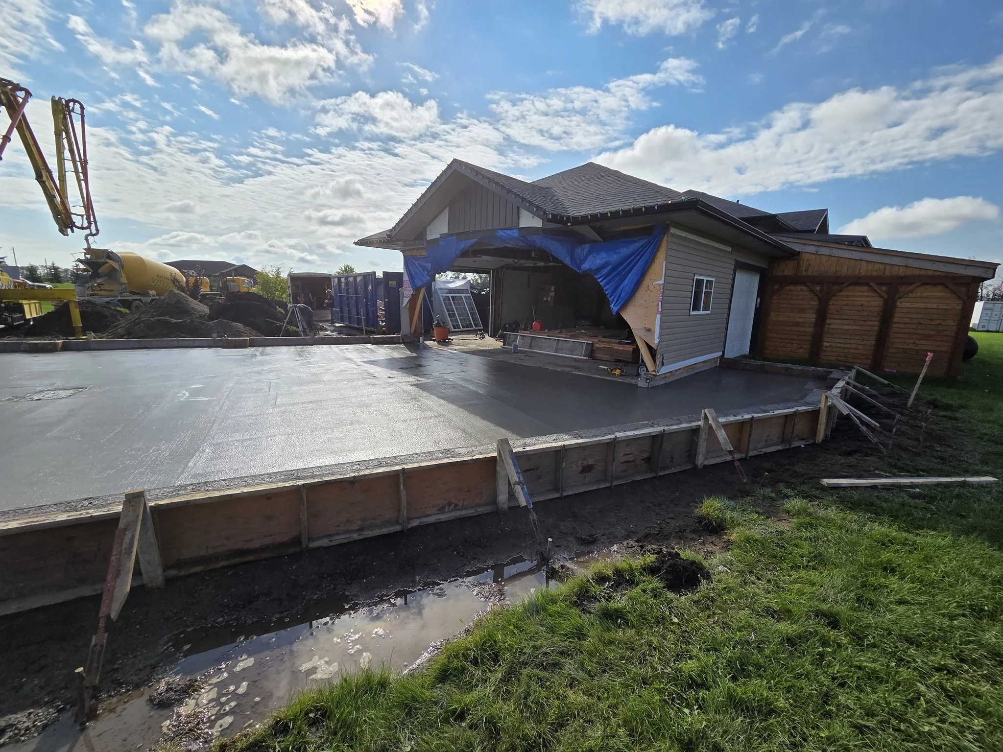 A freshly poured large-scale residential concrete driveway slab integrated with a garage apron layout on a luxury Parkland County acreage estate near Spruce Grove.