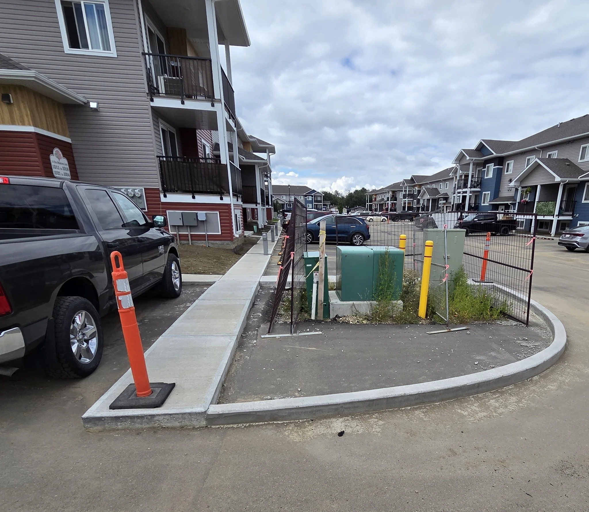 A completed commercial concrete radius curb and long connecting walkway for a multi-family townhome residential development in Stony Plain near Spruce Grove.