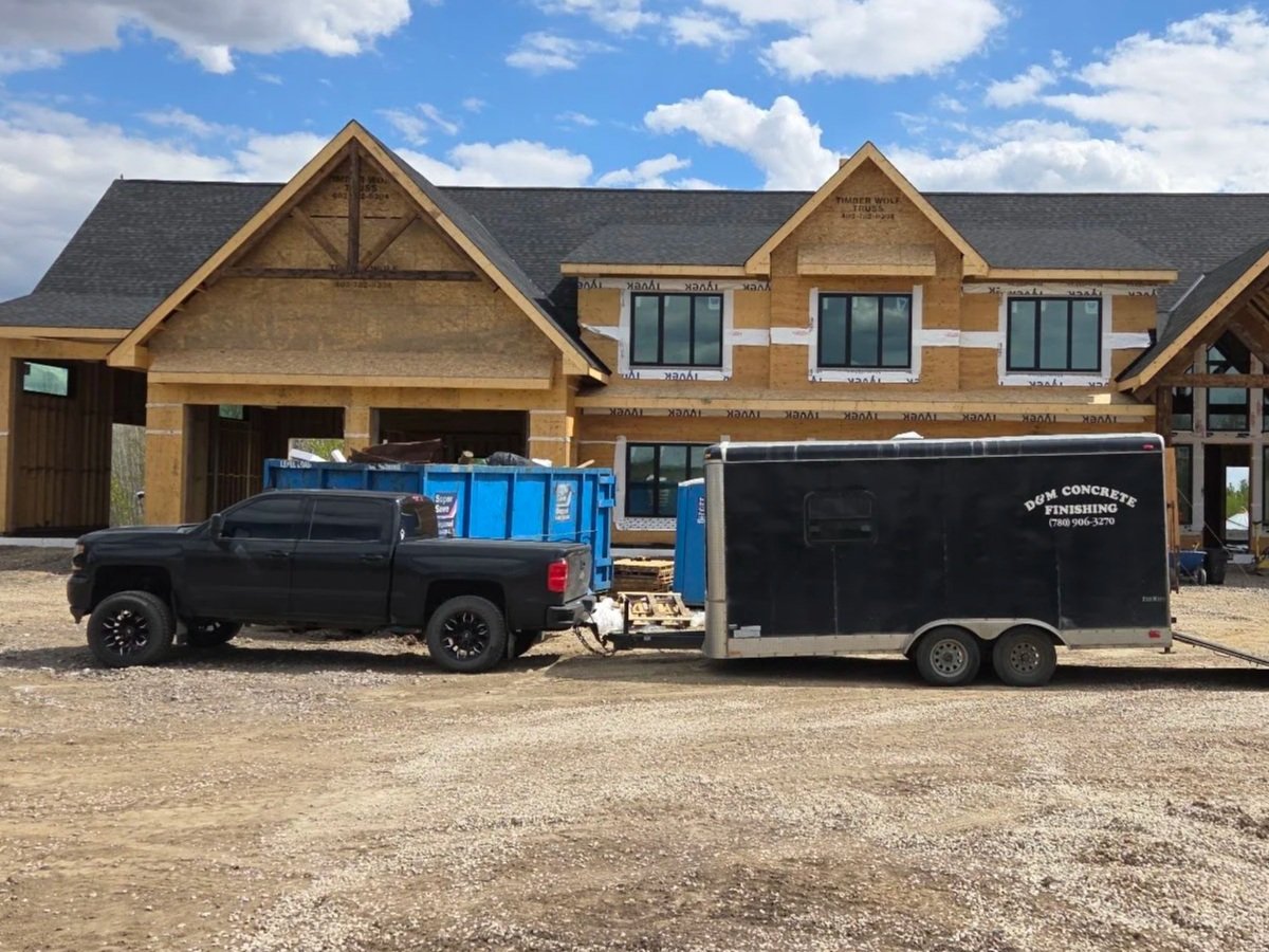 DM Concrete commercial fleet setup featuring a clean work truck and enclosed tool trailer fully mobilized on-site for a large development in the Greater Edmonton area.