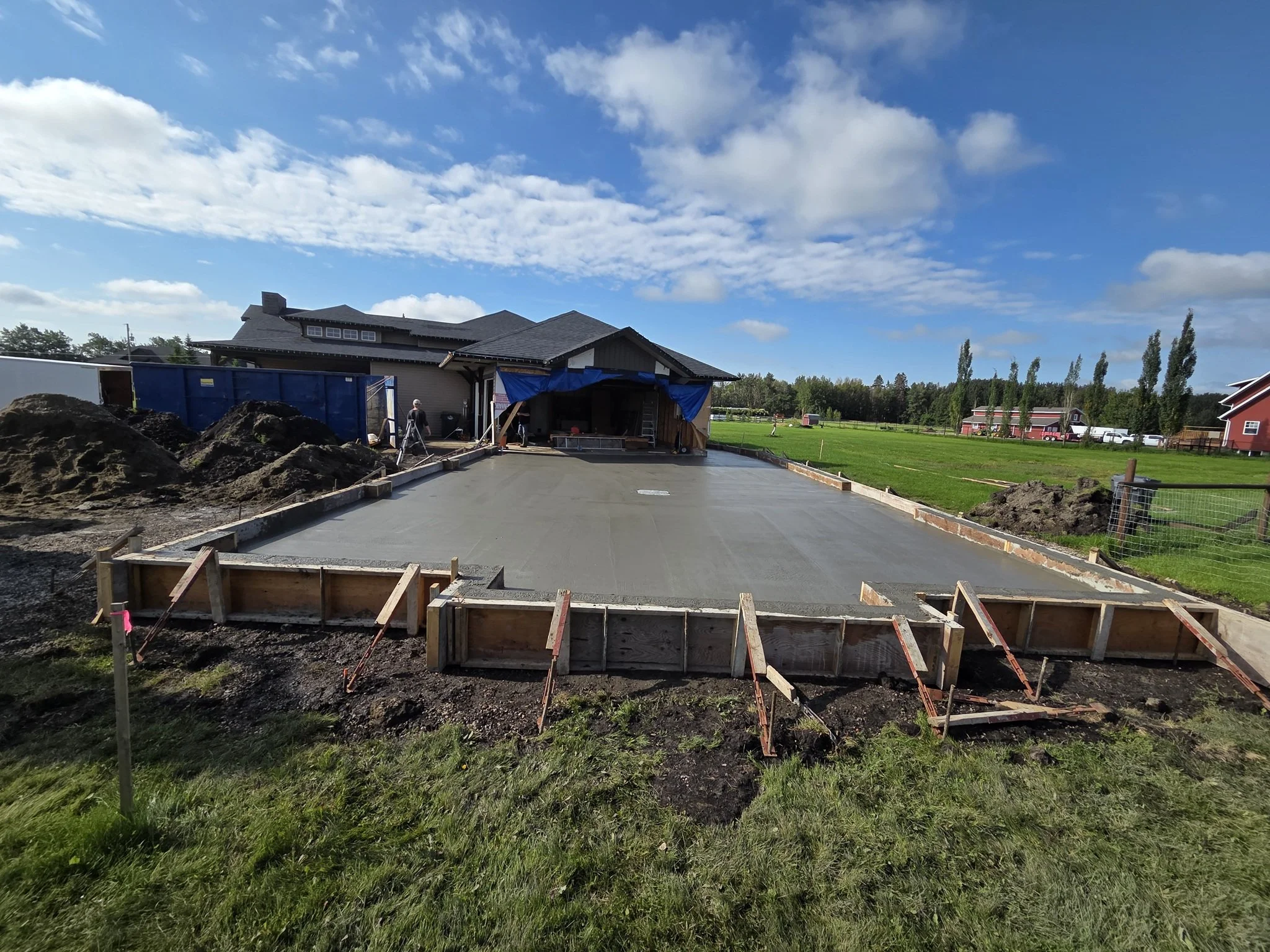 A massive freshly poured and perfectly leveled structural concrete driveway slab for a custom country estate home in Parkland County near Spruce Grove.