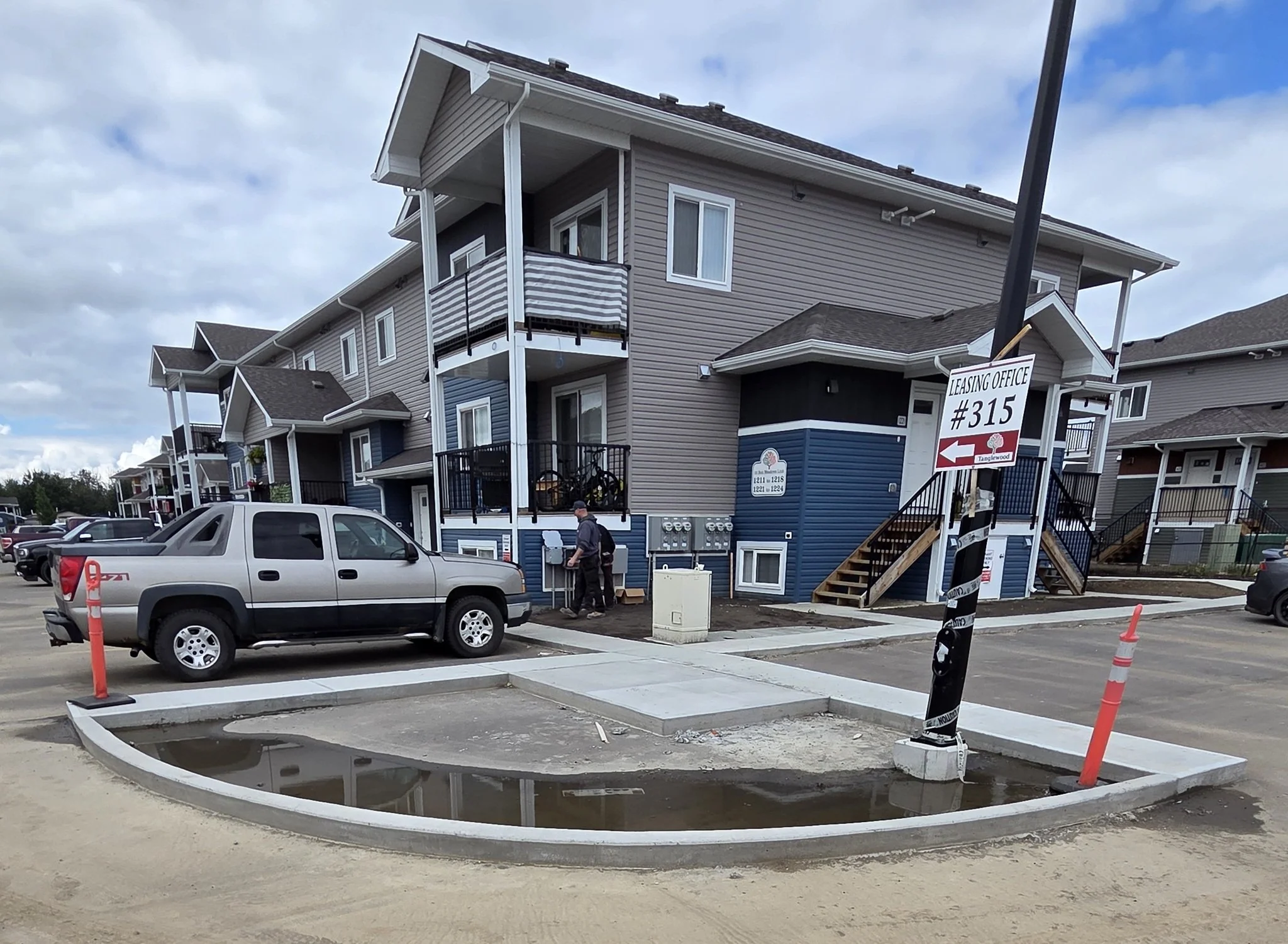 A completed commercial concrete radius curb and parking lot island with connecting sidewalks for a multi-family residential development in Stony Plain near Spruce Grove.