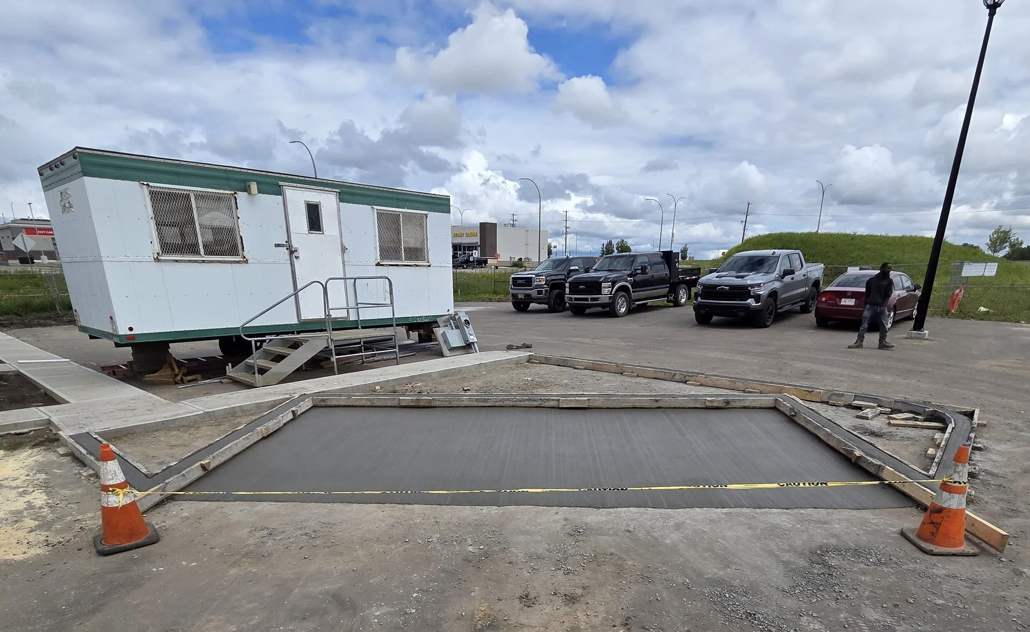 A freshly finished commercial concrete mail pad featuring a uniform broom finish, hand-tooled control joints, and protective caution tape in Stony Plain near Spruce Grove.