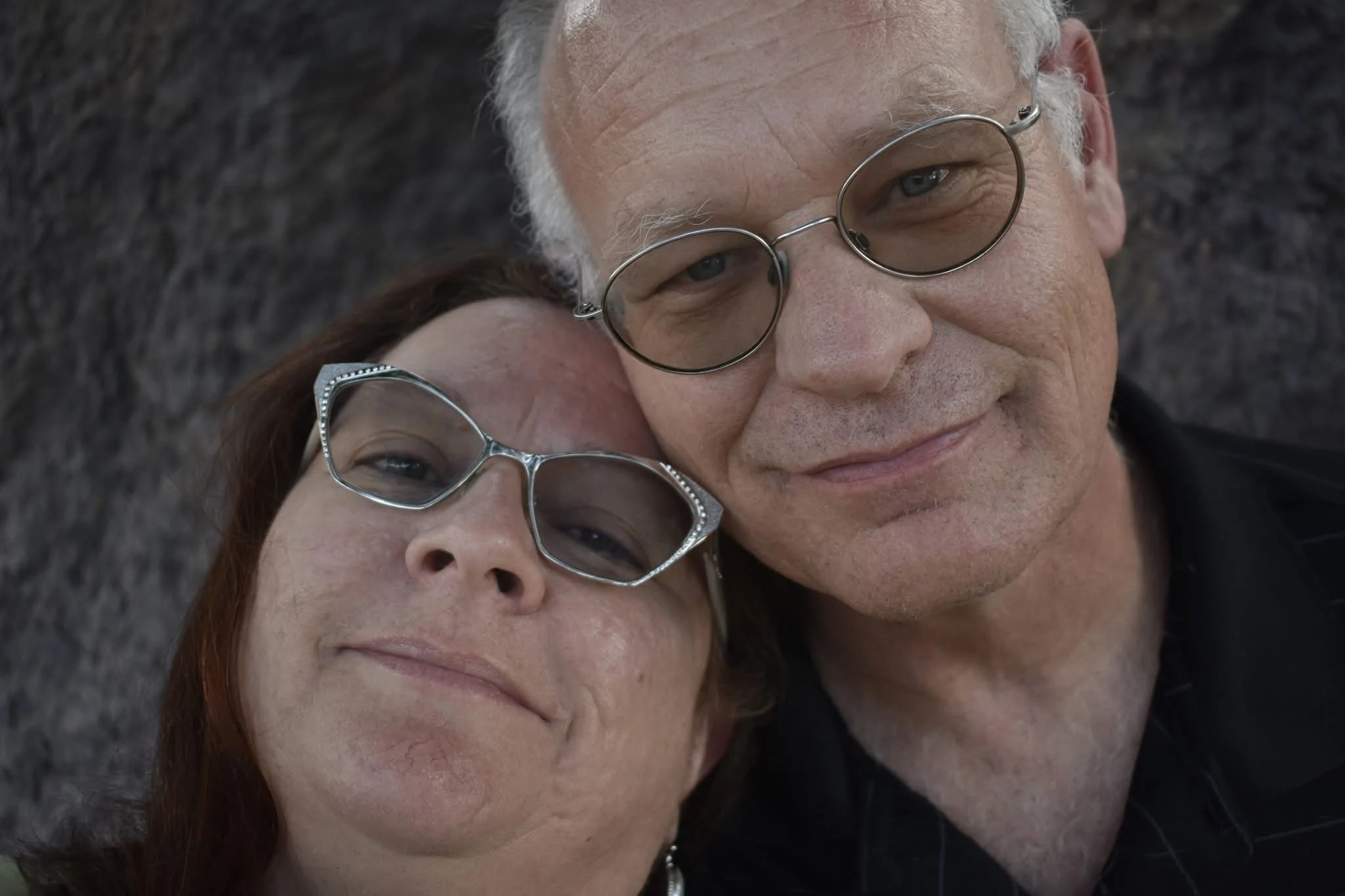 Richard and his wife near a large rock formation