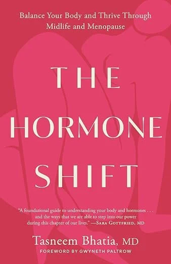 Book cover titled 'The Hormone Shift' by Tasneem Bhatia, MD, with a subtitle about balancing your body and thriving through midlife and menopause, featuring a pink background with faint outline of a thyroid gland.