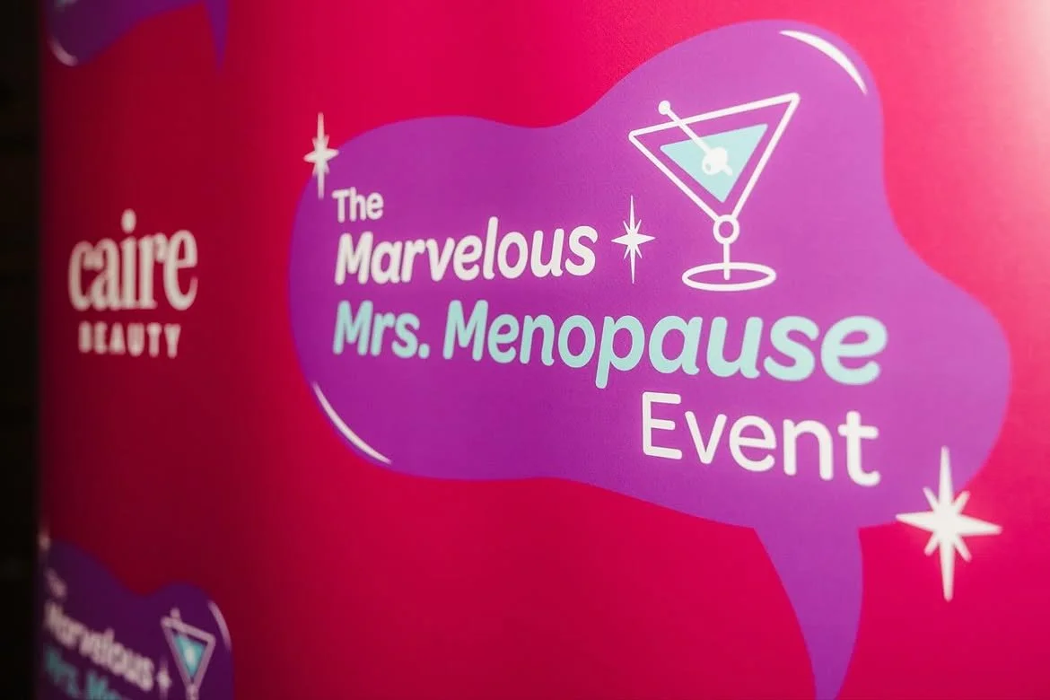 A promotional poster for Caire Beauty's The Marvelous Mrs. Menopause Event featuring a pink and purple background with white and light blue text, and illustrations of a cocktail glass and sparkling stars.